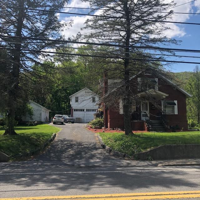This large brick cape cod style home has lots of old world character with it's woodwork, glass knobs and wood floors. With some upgrades and loving care, this home could be fabulous. Enjoy a first floor bedroom and full bath, spacious living room and adjoining family room area, a 3-car garage with electricity and another 2-car garage with an apartment above.  This property currently has long term tenants who rent the main house for $585 and the apartment for $425. Each tenant pays separate utilities except for the water and sewage which are combined and paid by seller.  You can keep it as an investment or enjoy it as a beautiful residential home. Lots of possibilities here. Schedule your tour! This property is offered in As Is/Where Is condition.