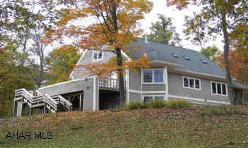 Dynamic nearly-new contemporary home. Cedar/Shingle with large yard and beautiful mountain view. Large deck, screen porch w/ storage shed under, oversized 2-car garage. Home Warranty Included. Basement level additional living space with private entrance. All floors tile and hardwood, 9' ceilings, heat pump with oil back-up.
