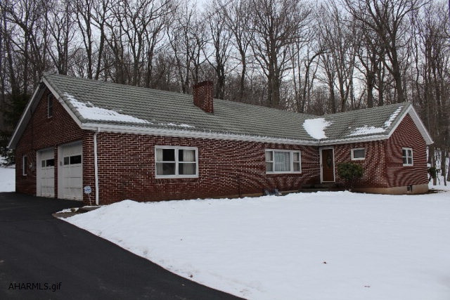 You want privacy and you want it close to town. This home is 2.7 miles from Pleasant Valley Boulevard and has 6.5 acres. Enjoy near maintenance free living with a brick exterior and a metal roof. Enclosed back porch/sunroom and a 2 car garage. Ready for you to finish the attic and basement for additional living space. Wood burning fireplace and hardwood floors throughout. Updated bathrooms are a nice touch for this home.