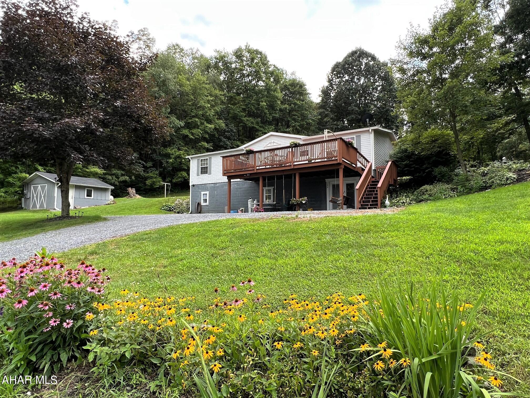 Beautifully maintained double wide home resting on 2.1 acres! Relax on your front deck while enjoying the peaceful mountains views! The main level offers a living room, dining area, kitchen, Pantry/mud room, owner's bedroom w/ en-suite bath, two additional bedrooms and another full bath. The finished basement has a family room, exercise room, laundry area, full bath and storage rooms. The full basement has a ground level walk-out to a concrete patio. Oil forced air heat, central air conditioning, well and private sewer. Two-car detached garage, storage shed and a large yard. Move-in ready!