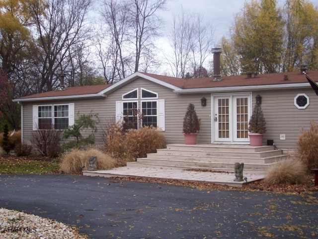 This is not your mother's double wide!!  Two fireplaces, natural gas heat, 3 spacious bedrooms, all new carpet and flooring, open floor plan, eat-in kitchen, and formal dining room.  Detached garage with hot water and heat and large bonus room (man-cave?) Must be seen!!Lot rent includes water & sewer, trash and snow removal.