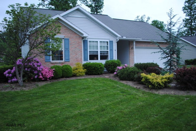 Lots of character in a nice development!  Great outside look with 130' of road frontage, brick front, very nice landscaping, back deck with joining stone patio and some trees for privacy.  Home has nice layout with entrance into a large living room and view of the dining room area with sliding doors to the back.  Three bedrooms and 2 baths - Master Bedroom has a WIC closet and private bath.  Front bedroom has an angled entrance into it and a big front window. Attached 2-car garage with entrance into the house at a laundry room and storage area.  A heat pump - low utilities.  Low maintenance!  The development is well maintained with added benefits.