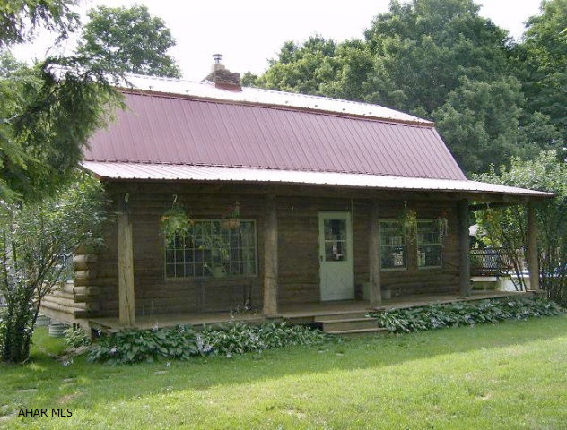 1 1/2 story actual log home on secluded 1.9 acres. 24 ft above ground pool with a large deck, workshop & garage. Too many items to mention. Also includes a 2006 Redman doublewide with ADA wood ramps to large deck/porch. In immaculate condition. Ideal for separate parent living or additional income. Each property has its own utilities. This is a one of a kind property!