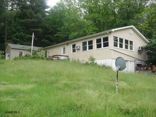 12.62 beautiful acres with a high tensiled fenced pasture, large pond, 30x41 pole building, and separate garage. Perfect for horses or cattle. Lots of fruit trees. House has 3 bedrooms, 1 full bath, oil furnace and wood burning stove. Singlewide that is now with a large addition to make a ranch home. Home needs lots of TLC. Shaffer's Creek borders this property. Must see this property to appreciate the beautiful location!