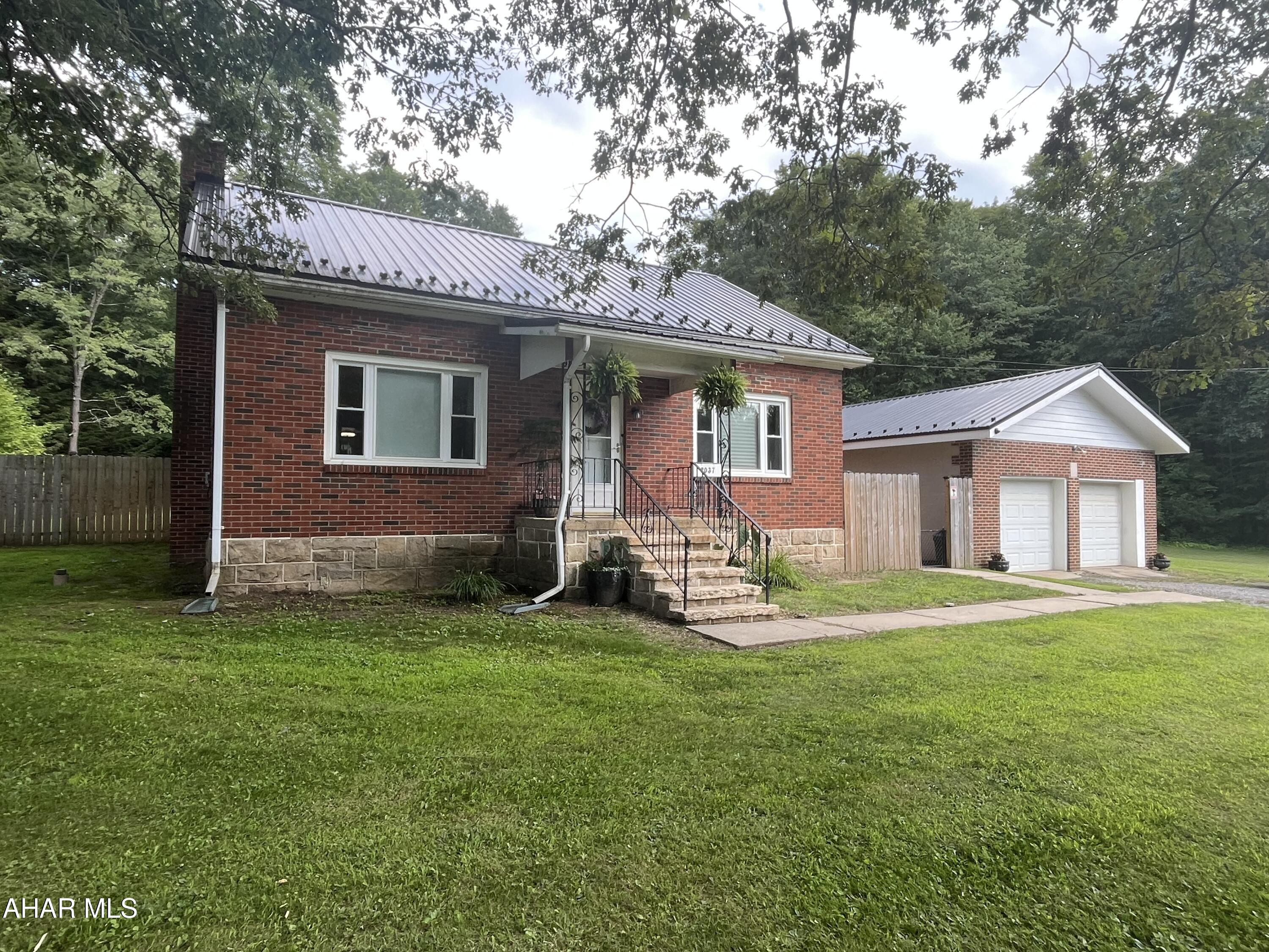 Charming and well-maintained, this classic brick home offers a spacious two-car garage and timeless character throughout. The main level features a comfortable bedroom with two walk-in closets and a full bath, while two generously sized bedrooms await upstairs. You'll love the rich hardwood floors and detailed trim that add warmth and elegance to every room. Downstairs, the clean and expansive basement includes a dedicated workshop, a bonus room with a fireplace—that is waiting for your finishing touches. Step outside to a fenced yard with a pavilion, ideal for gatherings and outdoor fun. Conveniently located just close enough to everything yet tucked away from the hustle and bustle.
20 Min to Altoona 
14 min to Prince Gallitzin State Park
30 min to DelGrosso's Amusement Park
Motivated Seller