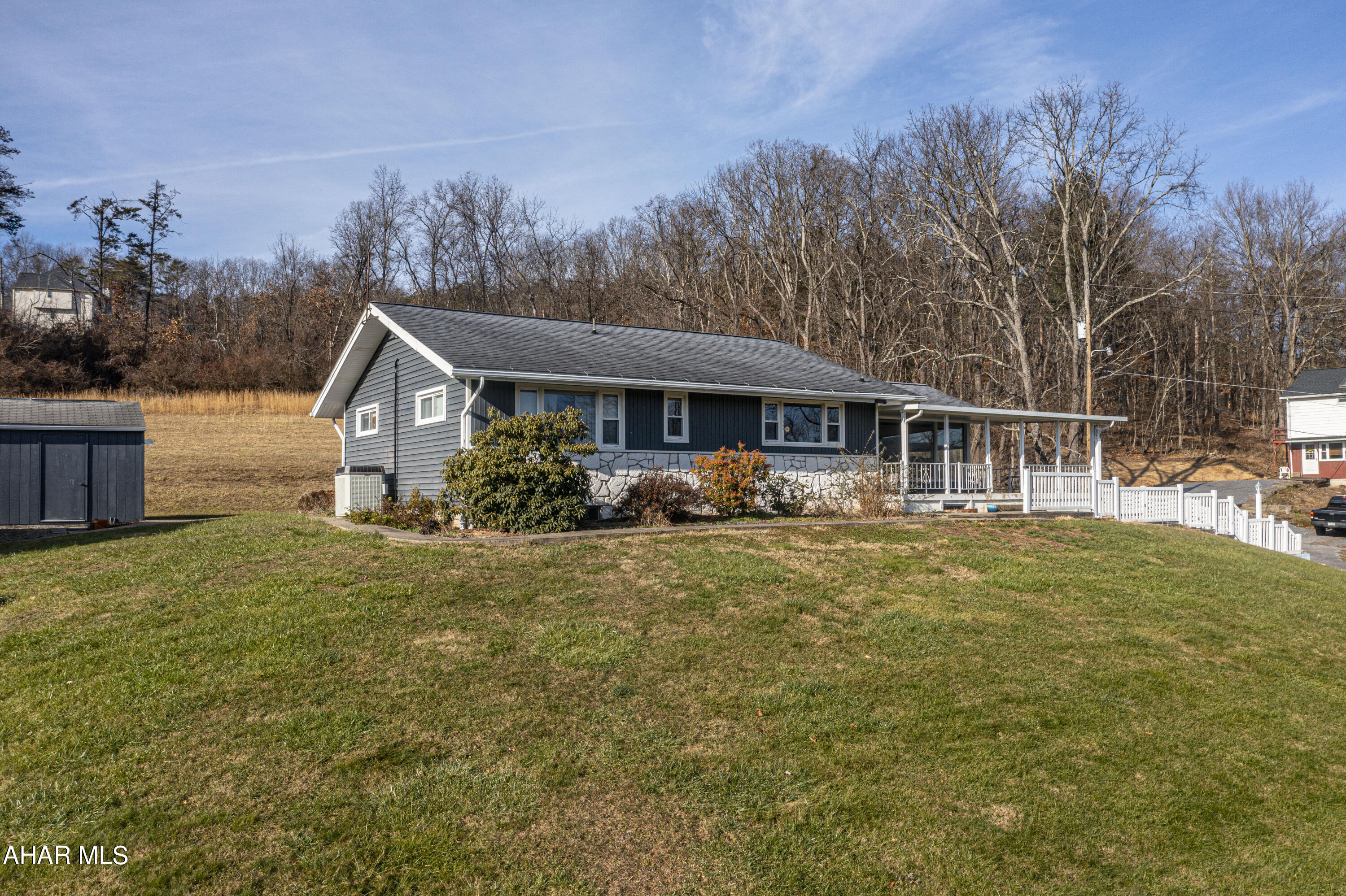 Welcome home to this charming ranch-style residence nestled on a spacious 2.05-acre lot. As you enter, you'll be greeted by a large covered front porch, perfect for enjoying the captivating views. Inside, the open concept design seamlessly connects the dining and living areas, creating an inviting space for family gatherings and entertaining. The home boasts three bedrooms and two bathrooms, including a convenient half bath in the master bedroom and in the basement. Hardwood floors throughout add warmth and character to the living spaces. An exceptional feature of this home is the expansive enclosed back porch, providing a versatile space for relaxation and enjoying nature. The property also includes an integral two-car garage, a paved driveway for convenient parking, a shed for additional storage, and an above-ground pool, perfect for cooling off on hot summer days. With its abundance of indoor and outdoor amenities, this ranch home offers a peaceful retreat in a picturesque setting.