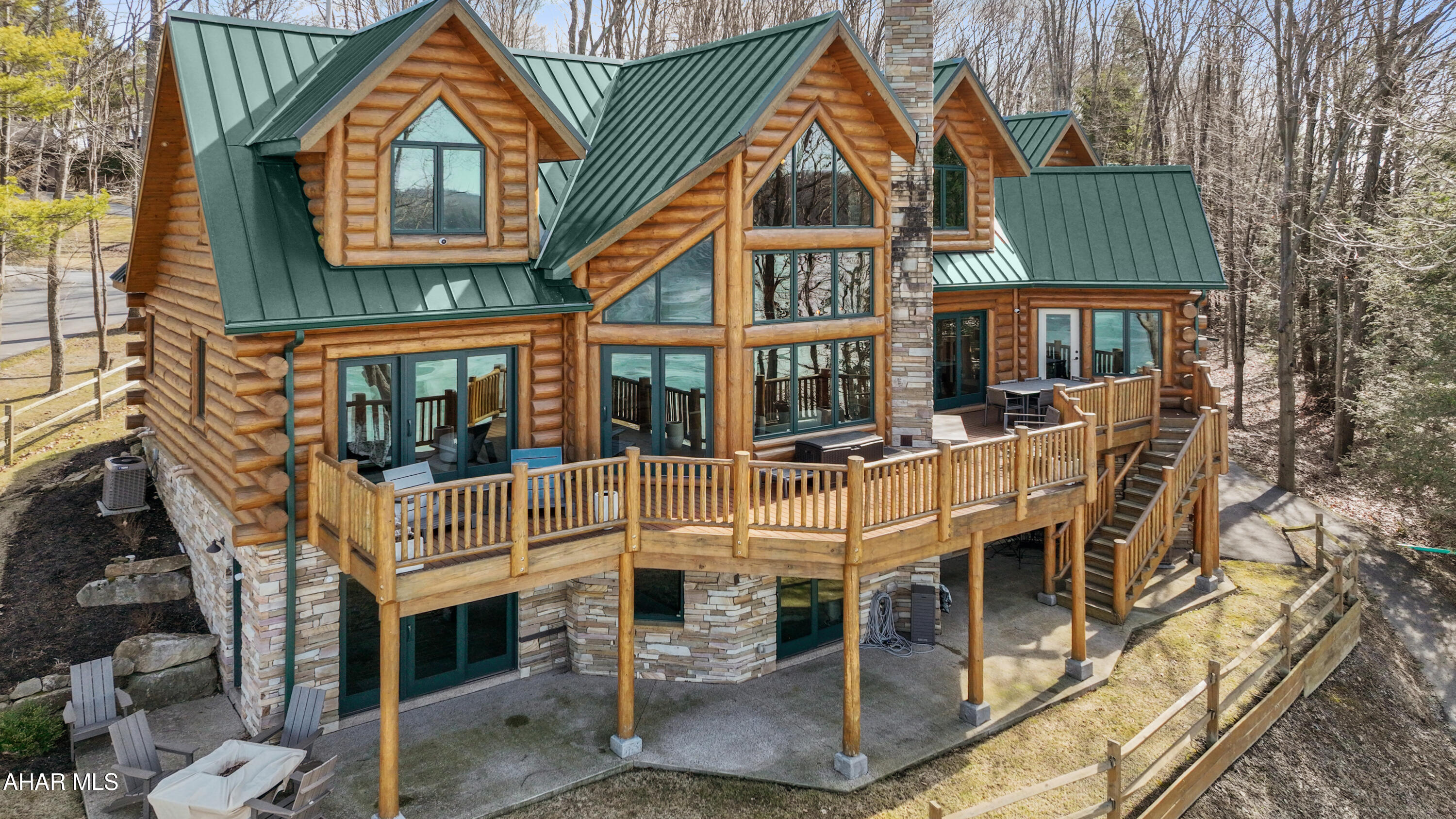 Immediately available and move in ready!!!  Absolutely stunning custom built log home overlooking Indian Lake!!! With remarkable water and mountain views, come experience all this incredible lake front home has to offer! The main level offers a two-story timber frame great room with stone fireplace and a wall of windows; kitchen with granite counters and peninsula bar; a den perfect for music, reading or relaxing; open dining area perfect for guests; primary suite bedroom with walk-in closet, and a custom bath with tile walk-in shower; mud room; half bath; and large laundry room. Open staircase leads to the second level offering three bedrooms; two full bathrooms; and a lovely sitting area. The fully finished walk-out basement has a rec room with wet bar and stone fireplace; living room; bedroom; and an additional bonus room currently used as an exercise area. There are views from every aspect of this quality home. Two-car attached garage and a one-car integral garage offer plenty of storage for vehicles and toys. Hardwood and ceramic tile floors; log and drywall walls; interior and exterior recessed lighting; granite counters and vanity tops; radiant floor and forced air heating system; and central air. Large rear deck with outdoor stone fireplace perfect for entertaining; beautiful boat dock w/ lift and upper deck for gatherings; concrete patio; and covered front porch. This is truly a gorgeous property with expansive lake views! Easy access to major roads, Pittsburgh, MD, and Historic Bedford.