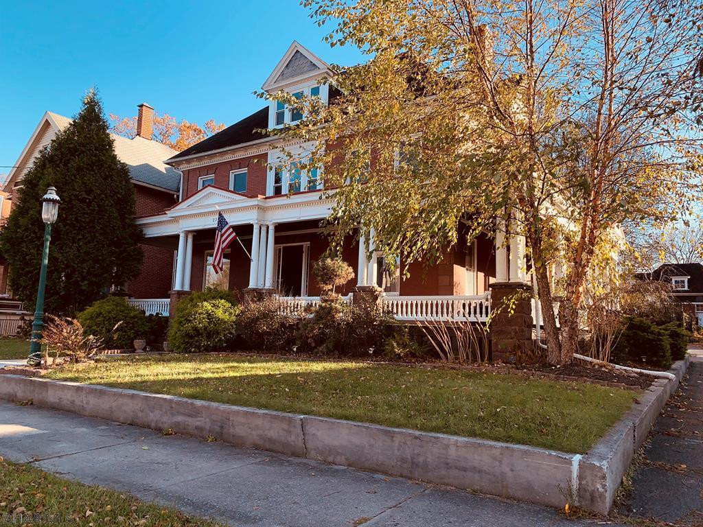 Impress visitors and friends in this stunning historical home known for its signature curb appeal with its large and inviting wrap around covered front porch.  From the moment you arrive, architectural details are extraordinary!  Preserving the integrity of the historic character is evident throughout.  One can only imagine the joy that comes from owning a piece of our town's history.  Pocket doors, arched hallways, grand woodwork and stained glass windows all make the home more appealing.  Updated kitchen with granite counters, butler's pantry and custom ceilings, newer windows combined with a new energy efficient natural gas are an added bonus.  Large carriage house with a huge yard surrounded by historically inspired fencing complete this unique house.