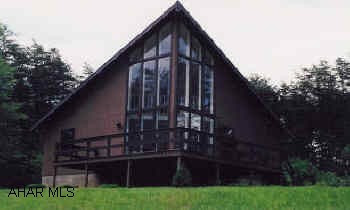 A-frame on wooded site, community lakefor swimming or fishing. Large deck.