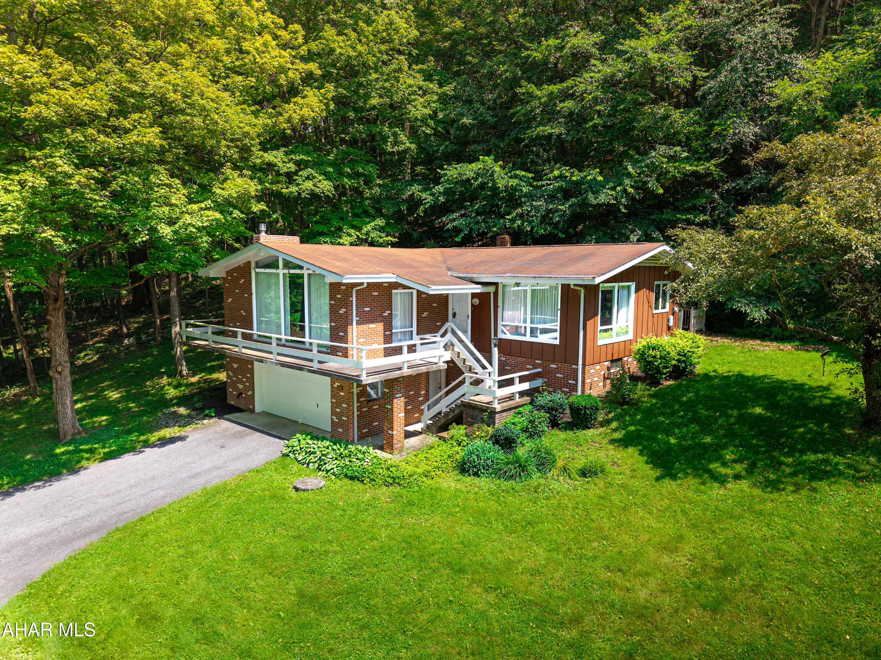 Well built contemporary home resting on a double wooded lot containing .851 acres. The main level offers a large great room with floor to ceiling windows, beamed cathedral ceiling, and brick fireplace; the perfect dining room to enjoy company, dinner, and views; kitchen with access to the rear porch; a primary bedroom with a bathroom; two additional bedrooms (one currently used as a den); and another bathroom. Wrap front deck to enjoy the views or retire to to the rear covered porch to relax and watch the wildlife. Full basement with a one-car integral garage. Basement provides for ample storage and could easily converted into additional living space. Oil HW heat, a private well, and private septic system. Nice country setting with stream frontage, close to Omni Bedford Springs Resort and Golf Course, I-99, and State Route 220. Make this your new home today!!