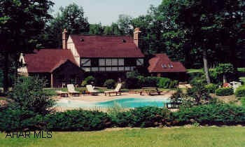 Expansive two story English Tudor on 10 private acres. Inground pool, patio, greatroom with fireplace and wet bar.