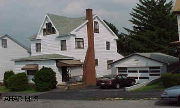 2.5 story, aluminum sided home with double lot and 2 car detached garage.