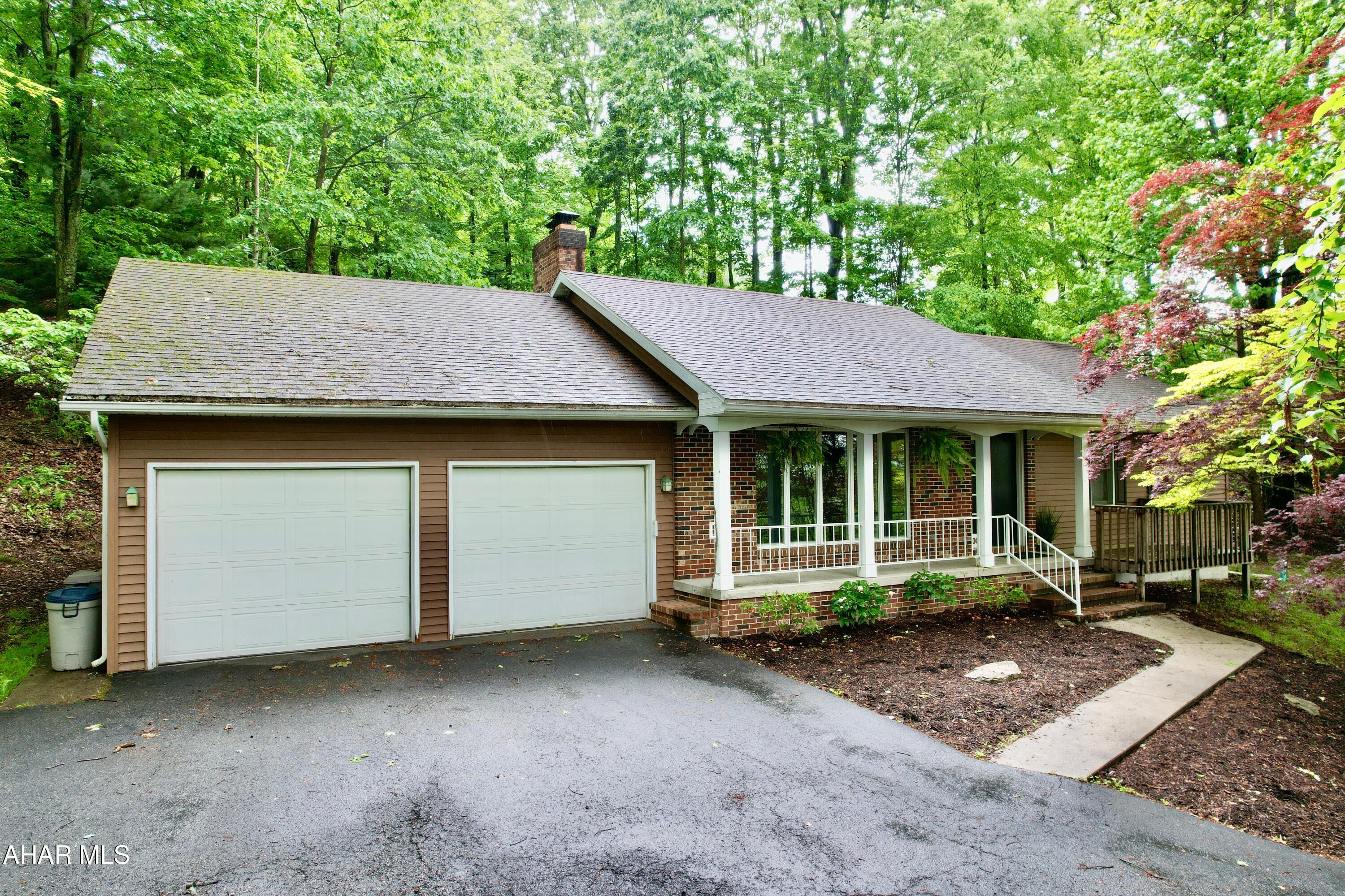 Nestled in the trees is this beautiful brick ranch home that overlooks the Borough of Bedford.  Sit on the front porch and enjoy the views, or sit on the back porch and enjoy the private back yard. This home has large living room with a wood fireplace.  The eat-in kitchen has a wood burner for secondary heat source or maybe just for the pure enjoyment of wood heat.  The kitchen has sliding glass doors that lead to the back yard.  The laundry room is on the first floor off  the kitchen.  3 bedrooms with 2 full baths.  The basement has so much potential for additional living space. Private driveway with off street parking, 2 car garage, with fenced in back yard.  Walking distance to downtown.