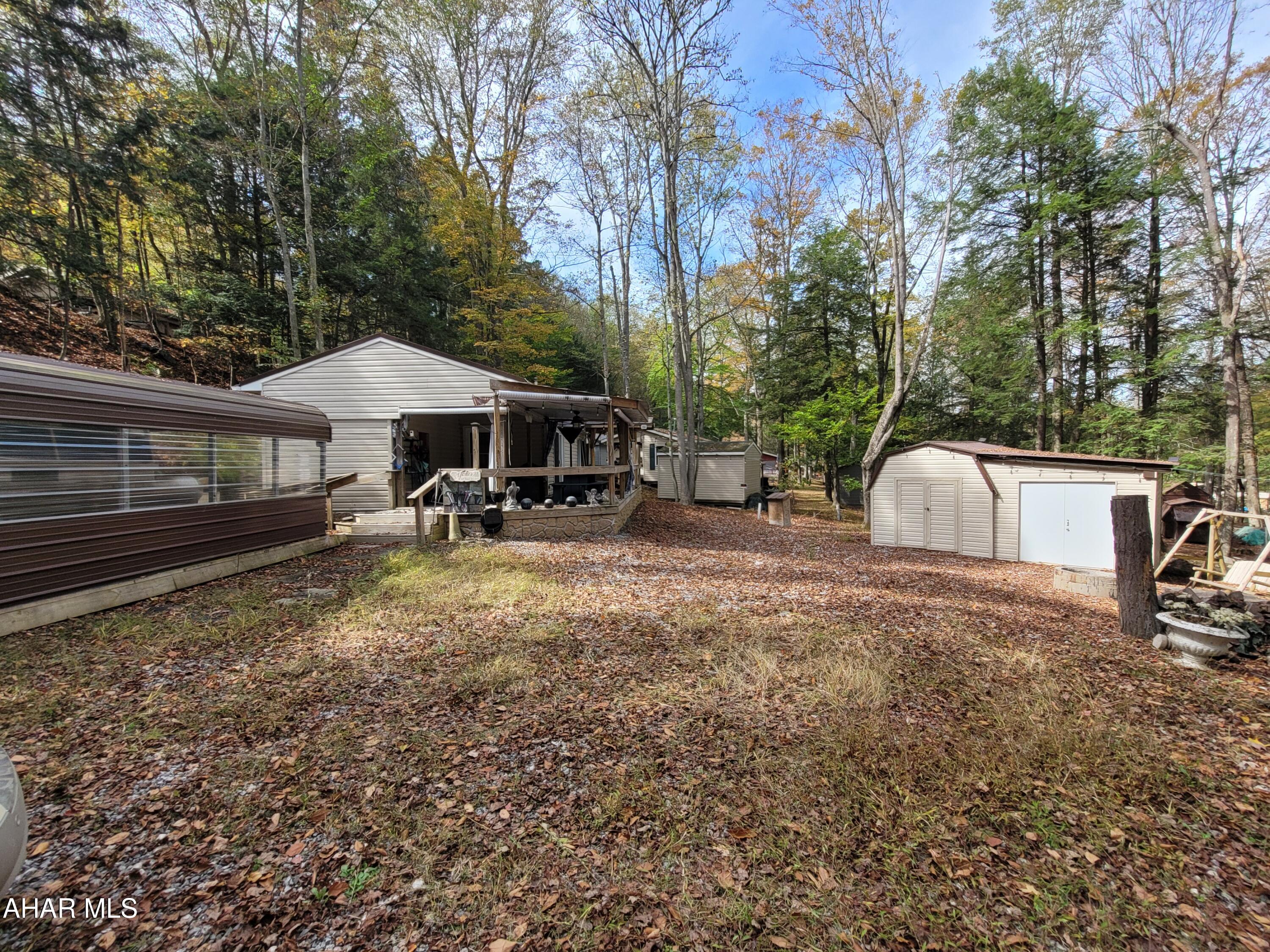If you are looking for privacy, space for the whole family and all the comforts of home, look no more.
This property is tucked in to a quiet corner.  The unit has an addition along with a large porch area, a pavilion cover for your boat, car or golf cart.  The large shed houses a washer and dryer along with an additional refrigerator.
Utilities are set up for year round living.