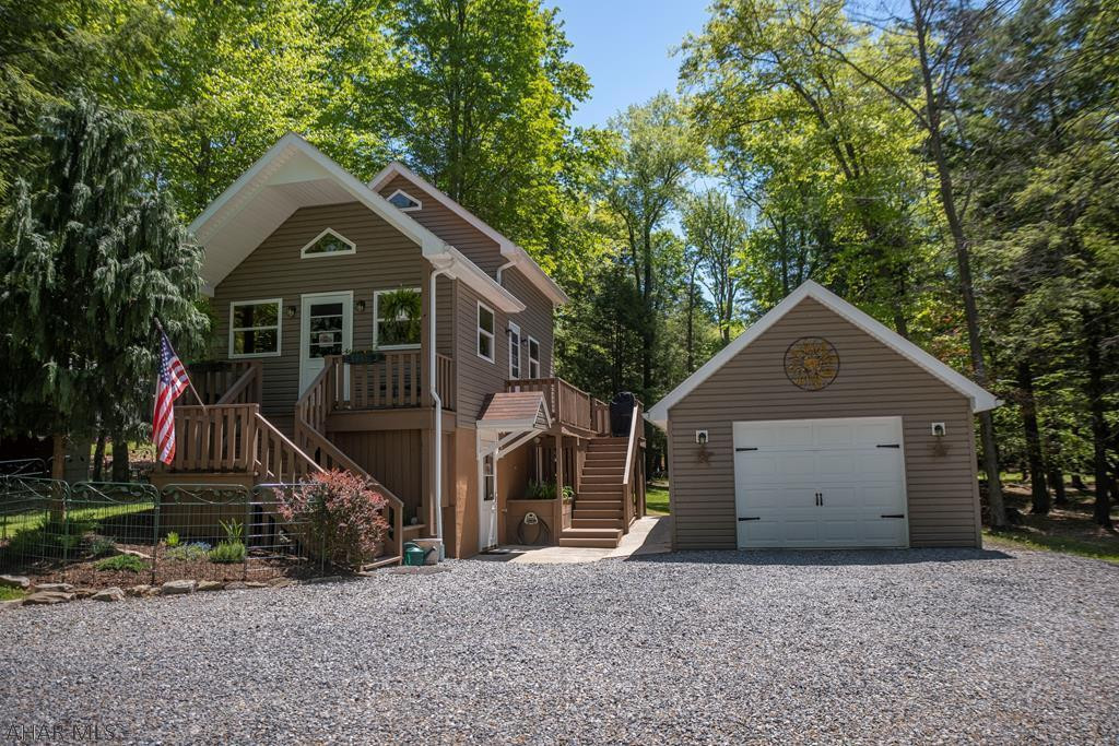 Whether you are looking for a cozy nest for two or a getaway for family this well cared for cabin could fill the bill.  Three levels of living space afford room for all to enjoy separate activities.  Lower level is currently a media room but could be redesigned as a bedroom.  The loft bedroom offers views of the living room as well as the view.  Wrap around deck off of the kitchen allows you to eat inside or out.  Lovely landscaping.  With two garages and a large shed you will have plenty of room for your vehicles, tools and toys.  Enjoy the community swimming pool, club house, tennis courts and playgrounds.  There is a place for Fido at the dog park as well.  Adjacent to Prince Gallitzin State Park / Glendale Lake, State Game Lands and six miles from Rock Run ATV Park.  Don't wait!