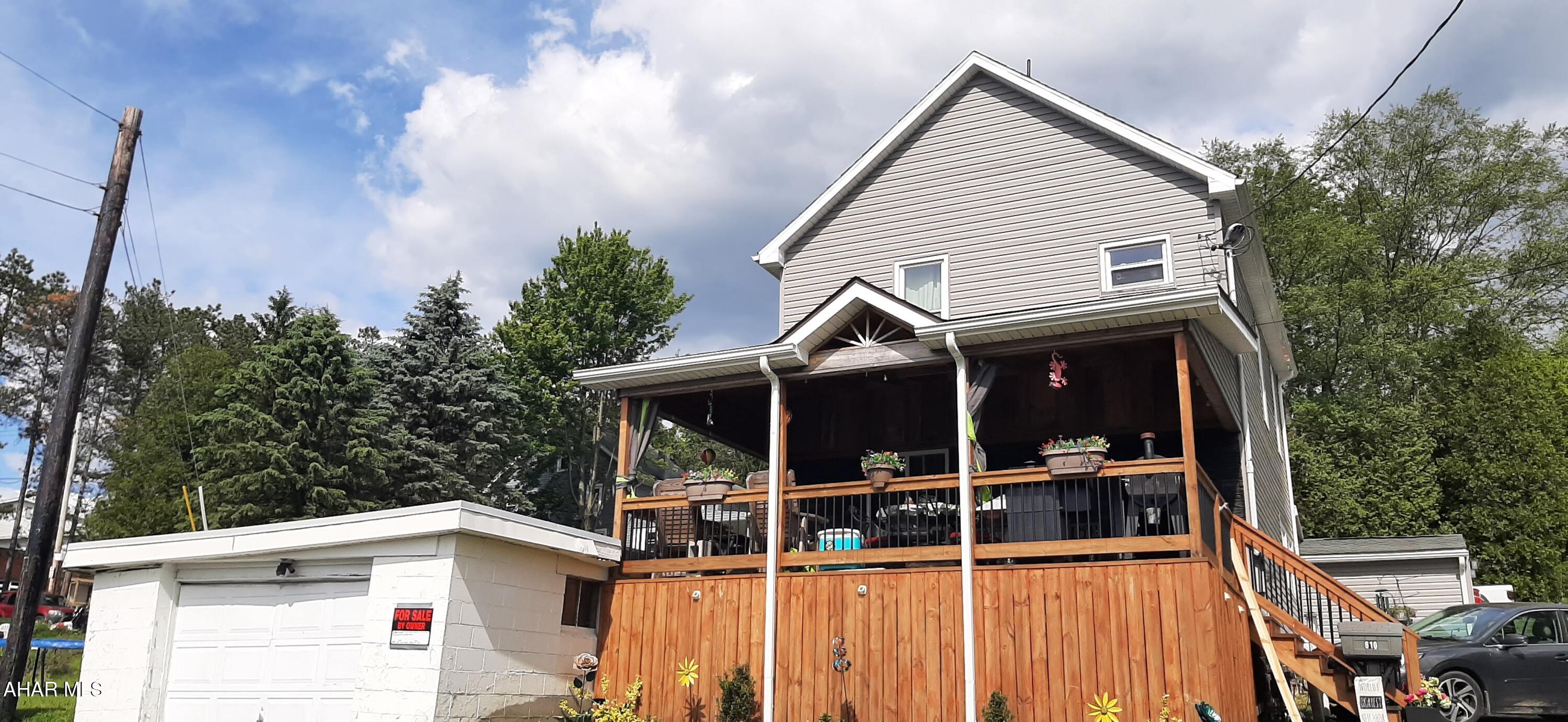 Welcome to this character filled home that has been lovingly remodeled. Walk up the front steps to the massive covered deck overlooking the west side of Gallitzin. Here you will enjoy watching the trains and the beautiful sunsets. Through the front door you will find an open foyer with the original staircase banister refinished and new stair treads. The wood accent walls are of walnut and beech. The lovely laminate flooring flows seamlessly through the entire first level. The living room offers a fireplace wall and large windows for great natural light. The kitchen is open to the dining room with a peninsula dividing the two spaces. Plenty of hickory cabinet space, stone backsplash and gorgeous black leather granite countertops for a unique look the ''chef'' will appreciate. All the black stainless appliances are included to compliment this spacious kitchen. Serve your meals in the bright & airy dining room, with room for a large table or use the peninsula with seating for at least 3-4. The dining room flows into the laundry room and full bath that both have their own unique touches and accents. The side entrance has the mud room for your ''drop zone''  to remove shoes and storage needs. Upstairs you will find more character throughout. The same laminate flooring flows upstairs into the hallway which leads to 3 great sized bedrooms and a beautifully renovated bath. The mechanics have also been updated with a high efficiency natural gas boiler with hot water on demand, 200 AMP updated electrical panel, and newly updated walk out to the integral garage. This home has so many unique features that you must see for yourself! Call for your tour today!