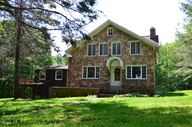 This tranquil setting is located on 5.2 Acres in beautiful Sinking Valley.  As you enter the front door there is a living room with built in bookshelves, and fireplace for entertaining.  Next you walk into the large dining room that overlooks the front yard that includes a stream,and fire pit.  The family room has sliding glass doors, lots of windows for natural light, and access to the wraparound deck.  The kitchen is a central location with access to each room on the main floor.  If there is not enough for you to do in this 4 bedroom 1.5 bathroom one of a kind stone house, the 4 bay garage will keep you busy, but that is not all.  This property also offers a guest house with 3 bedrooms and 1.5 bathrooms of its own.  The possibilities are endless, and you will never want to leave.