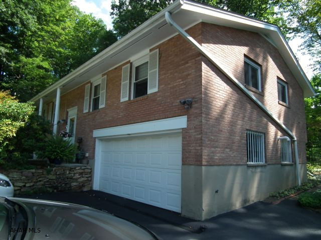 This split entry home is nestled in a private setting off Cedar Street. Home is surrounded by mature trees + shrubbery. This 4 Bdrm home's center for family enjoyment is located in this large vaulted beam ceiling adjoining Dining Room. While dining, enjoy a view of nature's beauty.  Your enjoyment can be extended on the oversized deck with built in seats. Hardwood floors under most carpeting. Added leisure time can be enjoyed in the screened patio. Utilities are as follows - Electric - $70.00/mo, Gas - $121.00/mo, Sewer - $32.00/mo, Water - $31.00/mo, Garbage - $22.00/mo