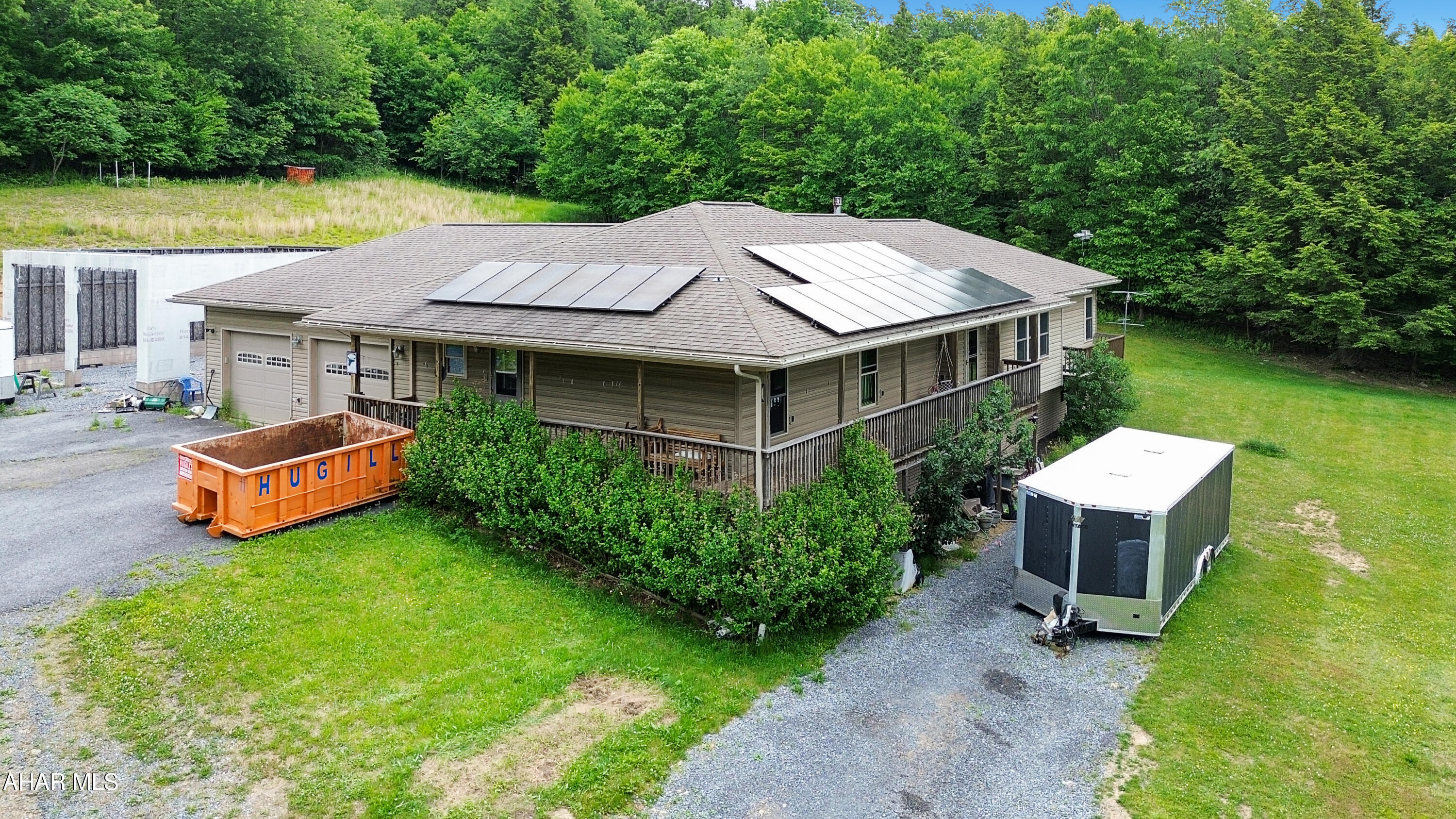 Built in 2009, this custom-built ranch home is nestled on approximately 6.7 private acres, offering the perfect blend of peaceful country living and endless potential. The main level features a spacious living room highlighted by a cozy propane fireplace, a large eat-in kitchen with an oversized island, and a private primary suite complete with double closets and a generously sized full bathroom. Also on the main floor are a formal dining room, two additional bedrooms, a second full bathroom, and a convenient laundry/mudroom. The walkout basement offers exceptional versatility with a separate in-law suite featuring its own bedroom, kitchen, living area, and full bathroom (not pictured). Additional basement space includes a dedicated office area, abundant storage, and utility/mechanical rooms. Outside, you'll find a two-car attached garage, an almost-finished detached two-car garage, a wraparound deck perfect for enjoying the scenic surroundings, solar power for added efficiency, and plenty of room to expand or customize to your needs. While the property could benefit from some finishing touches and cosmetic love, opportunities like this are few and far between. If you're looking for privacy, space, and tremendous potential, this one-of-a-kind property deserves a closer look. Call today for more information or to schedule your private tour!