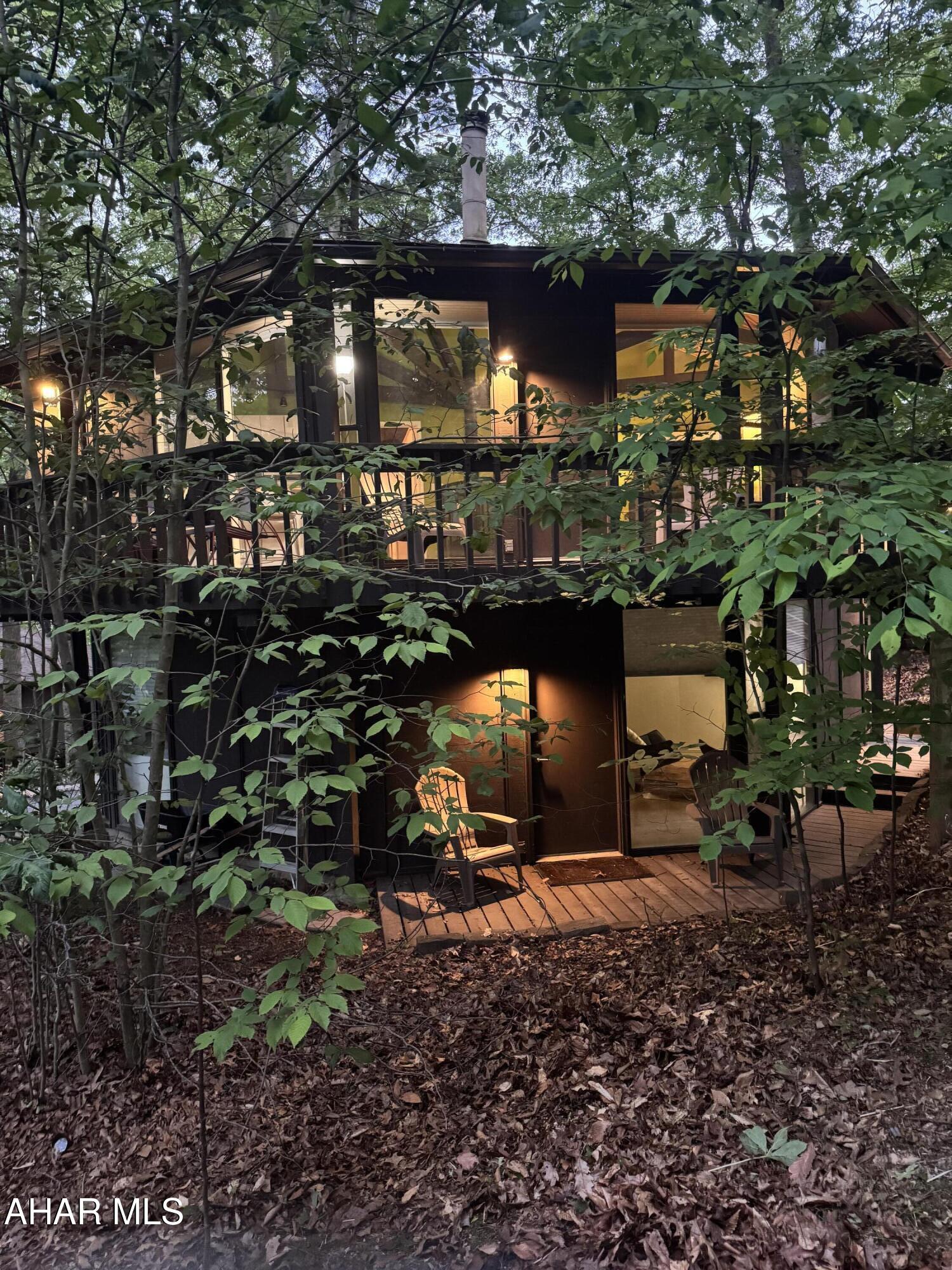 NEW PRICE! Everyone loves these Unique Homes, this one has you feeling like you are living in a treehouse. Sits nestled across from the Award Winning Omni Golf Course and Resort. Seller bought an extra .15 lot behind for added outside space . Walk in the door to lovely Brazilian hickory, hardwood floors on the upper floor. Kitchen has been updated with white cabinets, stainless appliances and butcher block counters. Cozy living room space. Two bedrooms on this level, each with its own full bath. Head down the spiral staircase into a relaxing family room/game room area with cork flooring. Lower level also hosts a third bedroom with its own bath. Heat pump forced air electric heating and central air, step down a few steps inside to the washer/dryer and utility room space. This property is turn key -walk in ready , either for your own home, rental or ARBNB.  Investors come take a look. This home was remodeled in 2020. Outside has a partial wraparound deck and lower deck area, with views of the mountains and trees.  Call for your tour!