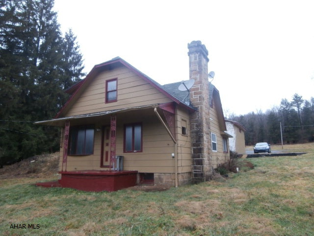 Property consists of a two bedroom 1.5 story house,(needs work), a mobile home pad currently rented for $230/mo, a detached 2 car garage with loft, pole garage and storage shed. Open septic tank next to house. House needs furnace. Being sold strictly in AS IS condition.