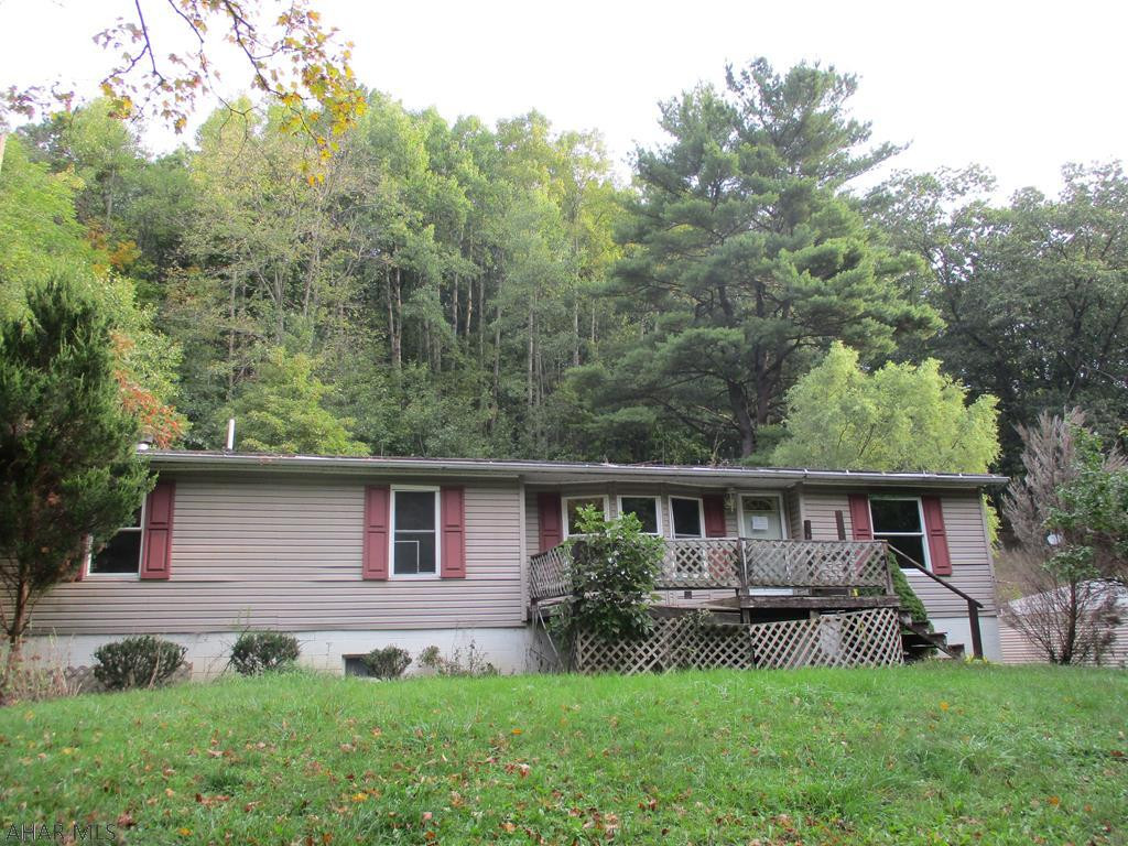 This is a Fannie Mae property. This is a mobile home on a full foundation. Located in a very quiet area outside of town on a 0.34 acre lot. Paved parking area with a carport for convenience. The main floor features a living room, main bedroom and full  bath with soaker tub, eat in kitchen, utility room, great room with fireplace, full bath and two bedrooms. Nicely laid out living space for one story living. The basement if full and unfinished for storage or other potentials with a walkout. Status of septic is only known from the tax records. Unknown type of septic  With some custom touches, this house could be your home.