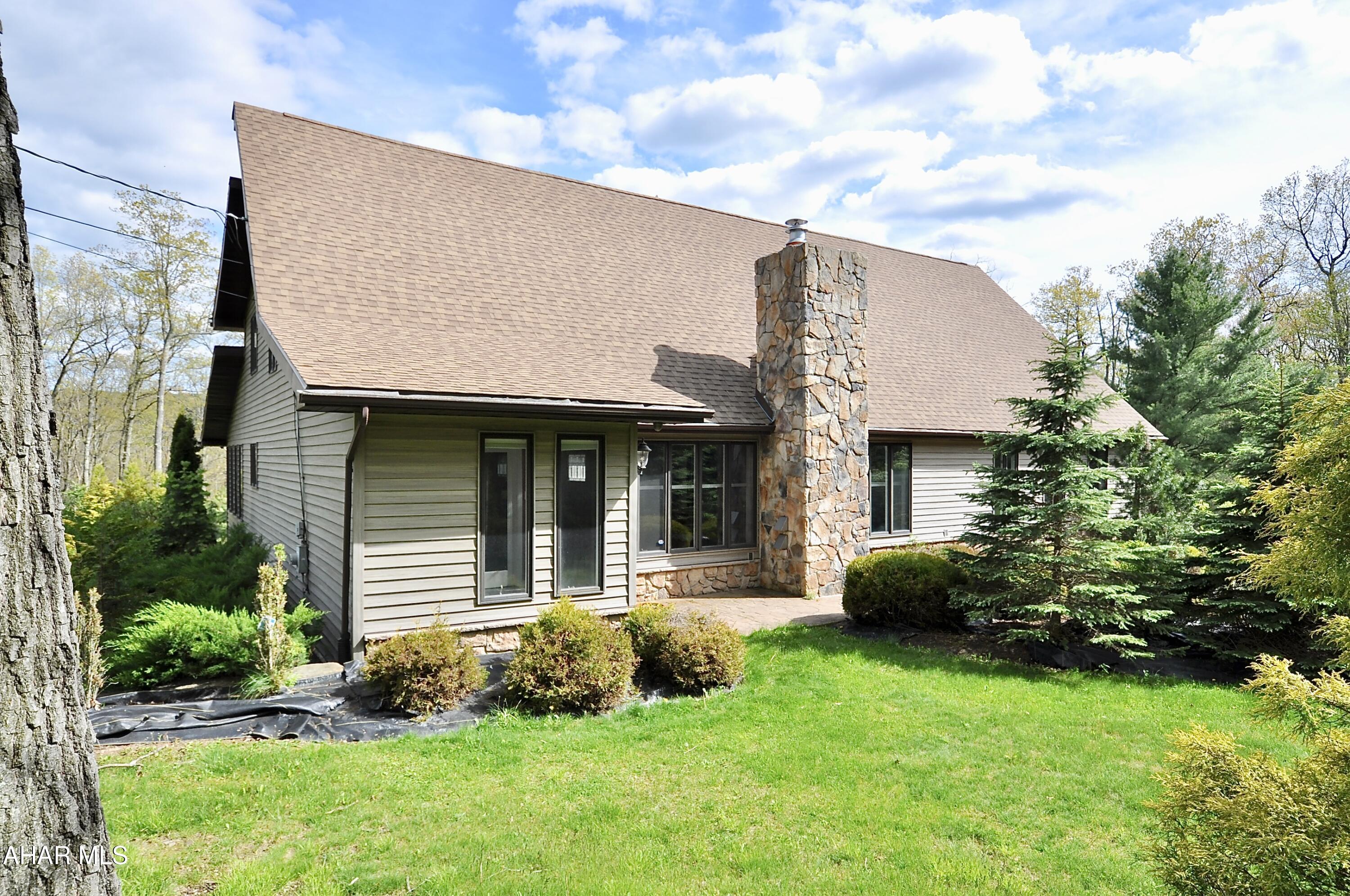 Wow! This huge custom built cape/salt box style, 4 bedroom home offers lots of room to roam! Situated on 4.49 beautifully landscaped acres on 2 separate adjacent parcels, the home contains 4,200 square feet above grade, and features a large living room with vaulted ceiling and stone wood burning fireplace, an inviting kitchen with large center island and lots of cabinetry and counter space, a sun drenched dining room, billiard room and recreational room equipped with wet bar, and a first floor bedroom with access to first floor full bath. Upstairs you will find 2 bedrooms, a full bathroom, laundry room, and private 4th primary bedroom with ensuite full bathroom equipped with large jacuzzi tub and shower. There are multiple decks where you can start your day with your morning coffee or entertaining on the weekends . This home has a 44 speaker hardwired sound system with individual volume room controls . In addition, there is a 16 camera security surveillance system as well as two separate central air units . The lower level contains 960 square feet of finished space to use for anything you like. Walk through 1 door into 975 feet of garage space that will house 3 cars. Outside, besides the amazing landscaping and hardscape, is a functional 30 x 96 foot hobby greenhouse and an additional 25 x 30 (2) car detached garage. This one of a kind property is a dream come true for anyone passionate about homesteading. So much house and acreage for the money! See the photos and then schedule your showing . You don't want to miss this opportunity. Only 25 minutes to State College and located in the Seven Mountain region of Potter Township, Centre County. Please note that photos of the greenhouse full of vegetables were taken by seller.