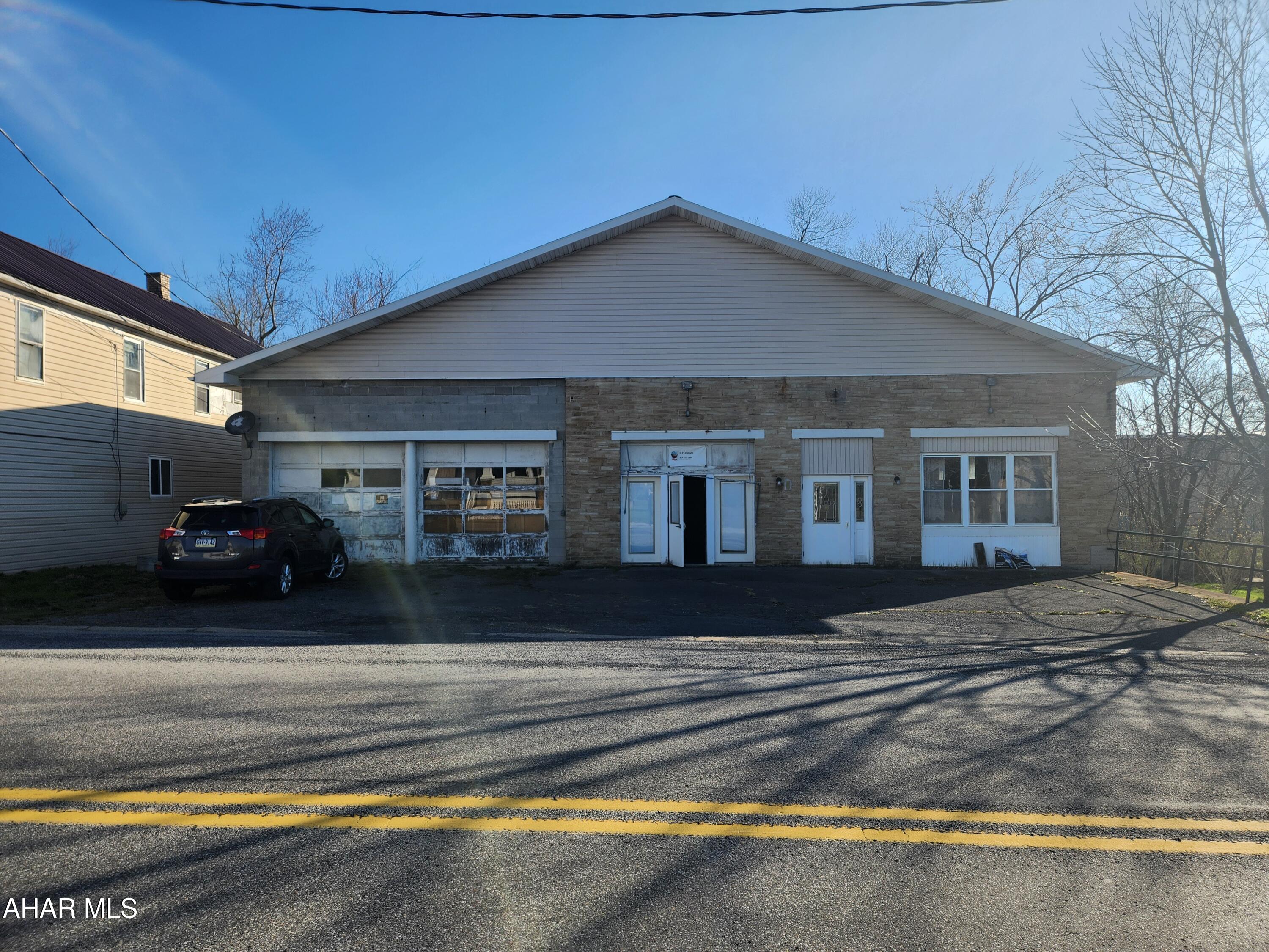 Attention investors!  Are you looking for an affordable mixed-use property?  Come have a look at this diamond in the rough.  With 2,100 sf of usable space on the main level, an 1,197 sf two bedroom apartment with an outside entrance in the lower level and an attached 572 sf two-bay garage, this property has a ton of potential.  Built in 1949, this was the original Alum Bank Community building and also home to CJ'S Delights, a bakery.  This building provides the opportunity for 3 streams of income; you could rent the apartment, the garage and the main level separately.  The main level has a large entrance area, a separate office room, a half bathroom, a room that was used for washing dishes and a spacious open area with kitchen cabinets and a sink.  With a little imagniation and a bit of TLC, this space could be easily converted into a cafe, a diner, a bakery again or whatever business you desire.  The apartment features an eat-in kitchen with oak cabinets, a spacious living room, a full bath, two large bedrooms and a separate entrance.  What are you waiting for?  Come take a look, this just may be the property you are looking for.  Buyer to verify square footage and acreage.