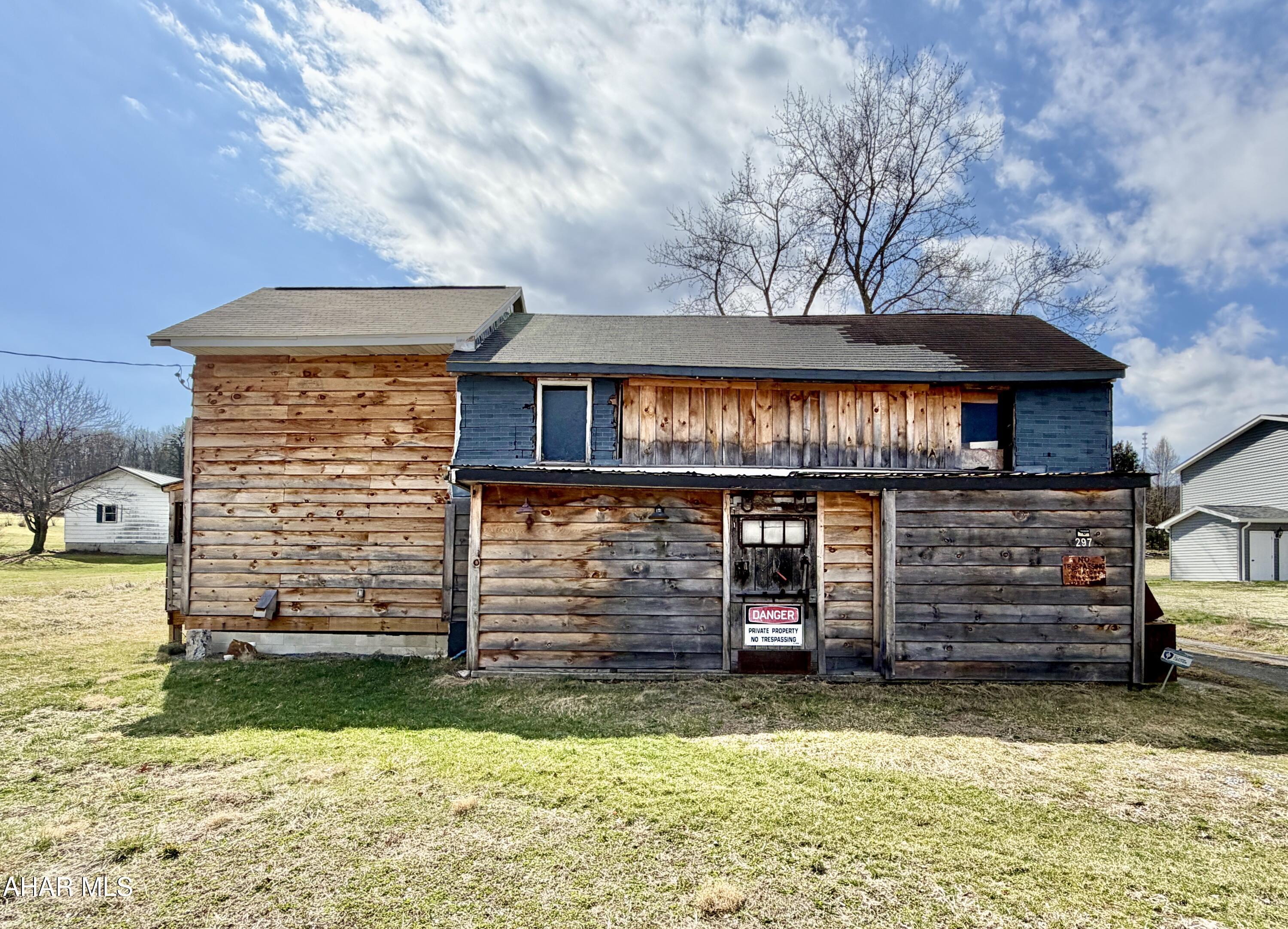 1.25+/- Acres with public water and sewer on site. The property offers a great location for multi-family housing, commercial space, storage units, truck/trailer drop yard, or a single-family home with no zoning. There are multiple structures on site and the large structure has hand hewn logs in a portion of it. The seller will make no repairs.