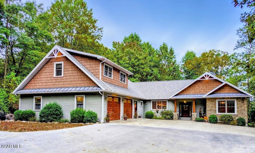 This luxurious ranch-style home offers an exquisite blend of style, comfort, and functionality, nestled on 2 private acres close to Raystown Lake and state game lands. 
Featuring a split floor plan, the home's central hub is an open-concept kitchen, dining room, and living room designed for seamless flow and entertaining. The custom kitchen boasts high-end appliances, a convection cooktop and wall oven, instant hot water, and a gorgeous island that offers additional seating and workspace. The living room is warm and inviting, with a gas fireplace and custom window treatments, perfect for cozy evenings. Step into the sunroom, where 14-foot ceilings and a stunning stone fireplace create a grand yet comfortable atmosphere. This heated and cooled space provides year-round enjoyment with views of the surrounding landscape. The master suite is a true retreat, featuring a spectacular bathroom with a large tiled shower, a deep jetted tub with a heater, and elegant finishes. Two additional bedrooms and a bonus room with its own bathroom offer flexibility for guests, family, or home office needs. The basement is designed for future expansion, with 9-foot ceilings, superior walls, and full heating, cooling, and plumbing already in place—ideal for creating additional living or recreational space. It also includes a whole-house water filtration system, ensuring clean and fresh water throughout the home. The oversized two-car garage is complemented by an adjoining workshop, both offering 9-foot ceilings, making this space perfect for storage or hobbies. Enjoy the TimberTek deck and the serene sounds of a beautiful waterfall feature, with a spacious patio ideal for relaxation or entertaining. Gather around the Breeo smokeless fire pit for outdoor enjoyment. In addition to the stunning main living spaces, this home features an upstairs bonus room complete with a kitchenette and a three-quarter bath. This versatile space is perfect for use as a home office, an extra bedroom, or even a mother-in-law suite, offering both privacy and convenience. With too many custom features to list, this home was built with attention to every detail, including aging-in-place features and handicap accessibility. This home balances comfort and luxury, making it a rare find. Don't miss your chance to own this exceptional property!