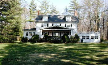 Beautiful and unique home on almost 5 acres of hard to find level ground.  Many Amenities. Beautiful eat-in kitchen with hardwood floor, Sub-zero Refrigerator, Viking Range, Separate Dining Room, Enclosed Hot Tub, Patio, Wooded Acreage, Shed.  4 zoned Hot Water Heat, Central Air.  Large Living Room connecting to Sunroom.  (Both have fireplaces.)  Finished basement with wet bar.