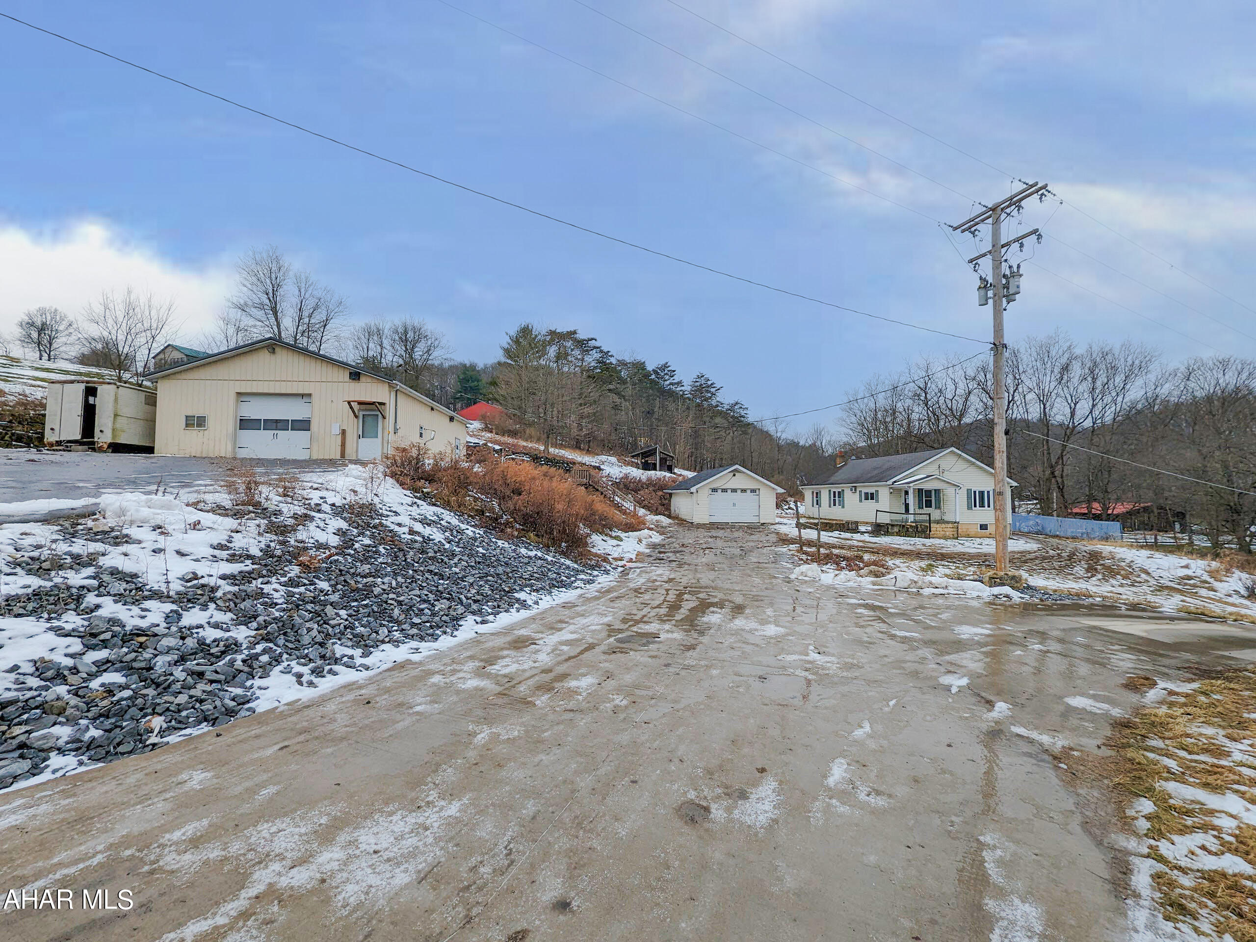 Rare find - 1.8 acres in Hollidaysburg area just outside of Canoe Creek State Park. Includes 1 story 3 bedroom residence, large workshop with overhead door, 1 car detached garage and large pole building w/ overhead doors. Currently zoned manufacturing - farming. Former overhead door company. Change of Use Permit required for other uses. Plenty of space to utilize, enjoy and make it your own. AS-IS sale. Seller will make no repairs.