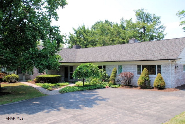 What a location!  What a lot!  Beautiful setting for this large ranch home with two large bedrooms and a total of four baths.  Huge great room with woodburning fireplace plus heated sunroom.  Circular driveway. 3 car garage and a beautiful view of the golf course and mountains in the distance.  Sprinkler system uses well water.