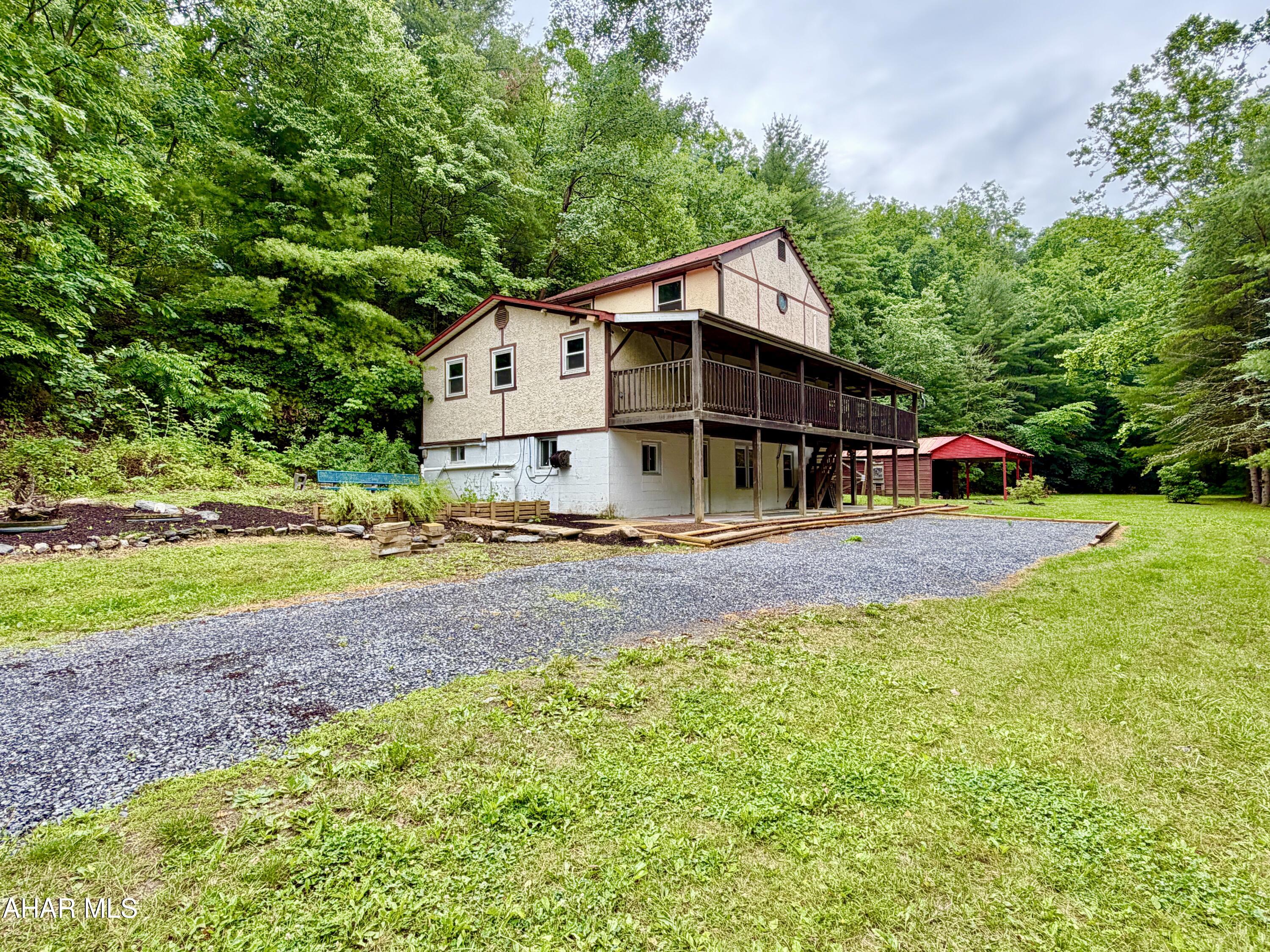 Nestled on 2.7+/- acres in a peaceful rural setting, this custom-built 3-bedroom country home offers the perfect blend of rustic lodge character and modern comfort. If you've been searching for a private retreat with unique craftsmanship and plenty of space, this property deserves a look. The main level features a spacious 23' x 23' great room highlighted by open-beam ceilings and custom flooring, creating a warm and inviting atmosphere. The large kitchen includes a custom island, propane heating stove, and ample space for gathering and entertaining. A full bathroom and access to the partial wrap-around deck complete the main floor. Upstairs, you'll find three generously sized bedrooms, while the basement offers a ¾ bath, laundry area, and workshop space, providing flexibility for hobbies, storage, or additional utility. Outside, relax on the partial wrap-around porch and take in the privacy of the surrounding yard. A shed/carport provides convenient storage for equipment, vehicles, or outdoor gear. This unique country property offers the ideal setting for year-round living or a peaceful weekend getaway.