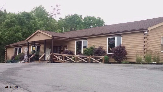 Location! Location! Prime business spot with tons of possibilities--- offices, retail shop, beauty salon/ spa, gym, pet shop, landscaping business, you name it --- whatever the commercial need! One story log building of approx. 5,000 sq. ft., with additional appx. 5,000  sq. ft.usable area of basement level. Cathedral ceilings, knotty pine walls and ceilings, hardwood floors on main level. Currently occupied by a resale shop utilizing both floors as their shop. Situated in front of motel 6, adjoining Orchard Plaza Shopping Center, only 2 blocks from Logan Valley Mall. Low taxes -- $2762.00 Situated on 1.72 acres in Logan Twp. Motivated Seller just reduced price  - What a great buy! Bring offers! Call listing agent for appointment. Taxes and square footage are an approximate.