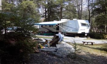 34 ft Prowler camper (2003) on corner lot close to fishing pond in original campground.
