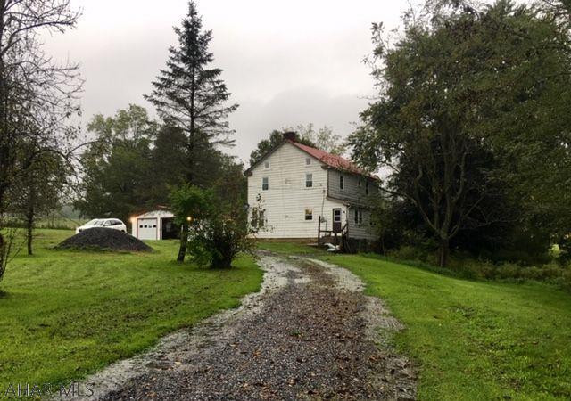 Lovely rural setting. Large home, new 2 car garage. Newer roof, updated electric, windows and furnace. Home needs TLC. 2+ acres with circular drive.