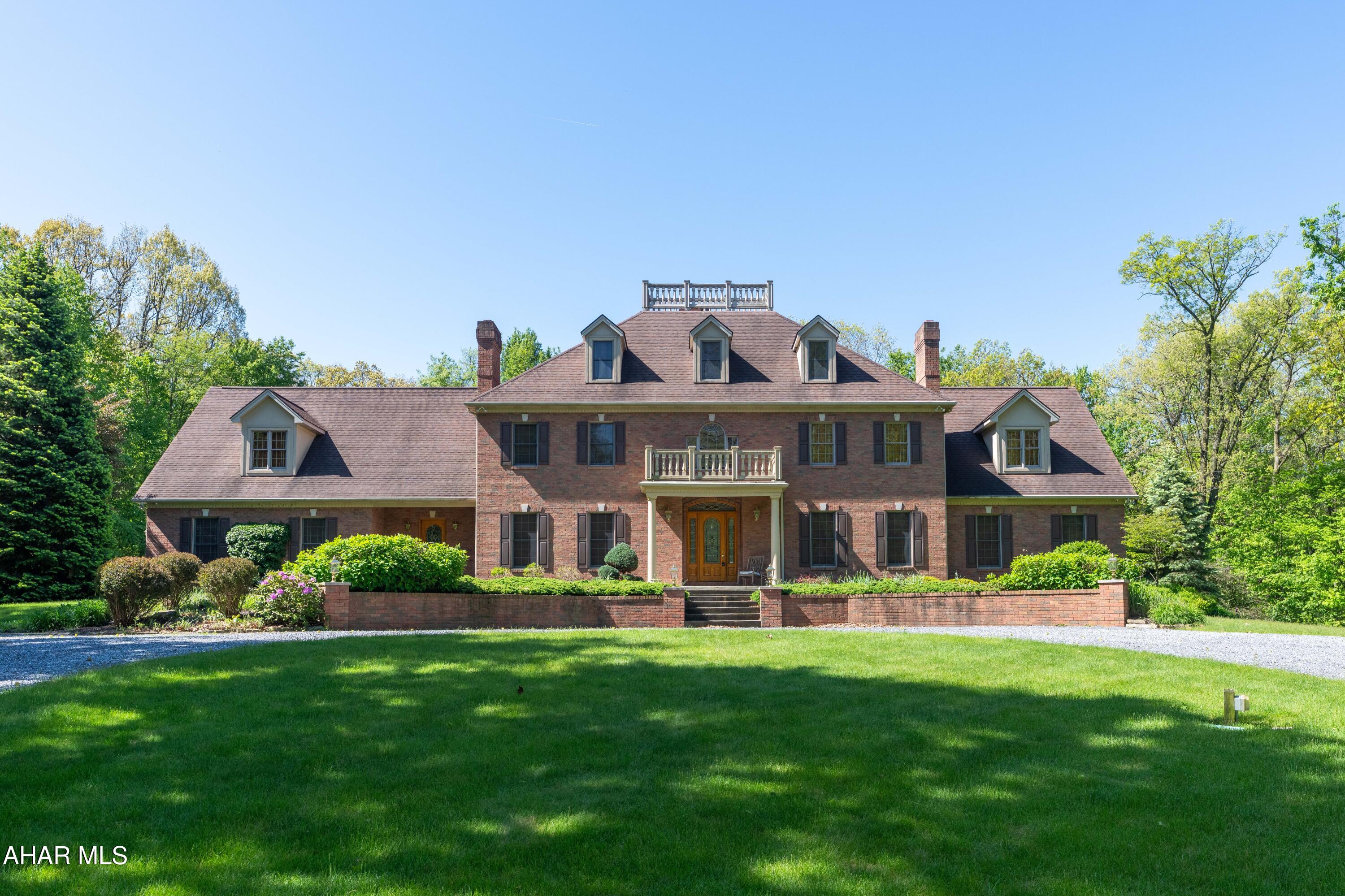 Stunning Georgian Masterpiece, entirely brick cased! This gated estate is set on 18 secluded acres, yet is minutes from I-99. A dramatic cathedral-ceiling foyer and sweeping staircase introduce this elegant country home. The gourmet kitchen features extensive cabinetry, a large island, and built-in wine rack, while the versatile layout offers up to six bedrooms and full  three baths. A first-floor owner's suite includes a fireplace, spa-inspired bath, and walk-in closets. Additional highlights include a four-car garage and private rear patio, creating the perfect blend of luxury, comfort, and serene countryside living. This home has so many amenities there are too many to list....it is truly a must see home!