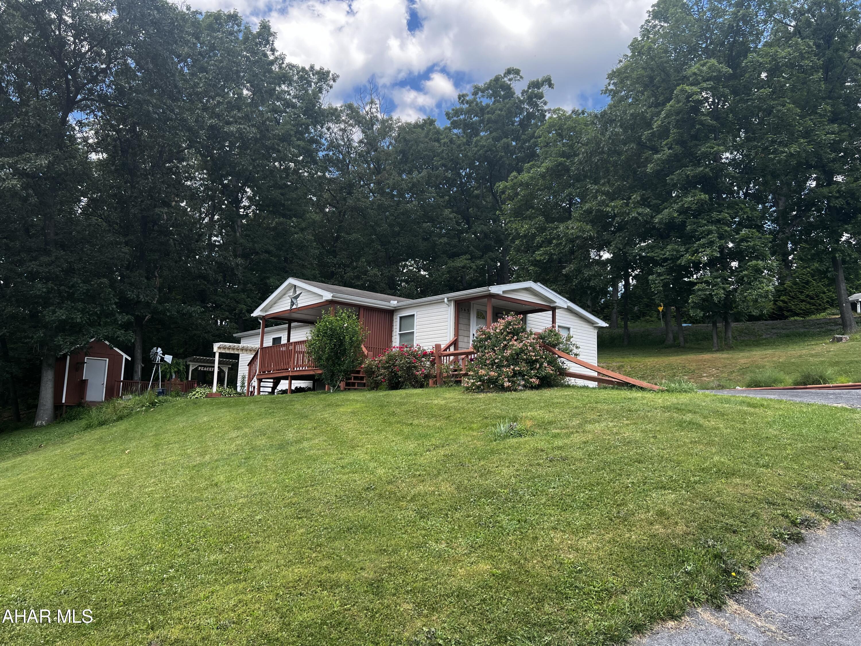 This immaculate home has been re-finished with dry wall, newer flooring, tile, and a completely upgrading kitchen. It features 2 bedrooms and a bonus room that can be used as a bedroom or utility room; as well as 2 full bathrooms. Enjoy sunsets on the covered front porch or entertain guests in the landscaped side space. This is a must see mobile home on leased land. Lot lease of $405/month includes trash removal.