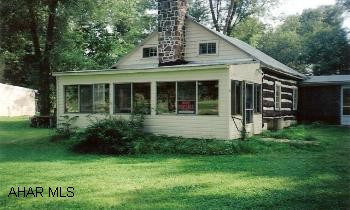 Nice stream front, log house w/3BR on .92 acre lot in picturesque setting. This house includes a large LR w/fireplace, screened porch and sun room. The home will require some repairs and is sold AS-IS