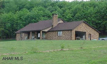 1 1/2 story, brick and shake home, 12 yrs old on 7 acres of beautiful land. Owner has recently had extensive natural oak woodworking completed in the home. Beautiful oak fireplace front. Cathedral ceiling with oak beams. The second floor has no carpet. sale subject to owner finding suitable housing. Spring fed water supply is located on the adjacent property over 300' from home. This supply has not needed treatment and has been unfailing in supply. There are two springs on the subject site that are not used.