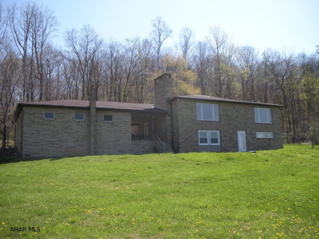One of a kind Block & Brick home on 4.2 Acres in Frankstown Township close to Canoe Creek.  This unique home has a reverse floor plan for sleeping.  Main level is all hardwood in living/dining and bonus rooms.  The lower level is where the bedrooms are located all rooms have windows, newly installed carpet, and nice closets.  There are 2 fireplaces.  There is a 2 car garage connected by a breezeway.  Plus an above ground pool.  Property is located next to State Game Lands.