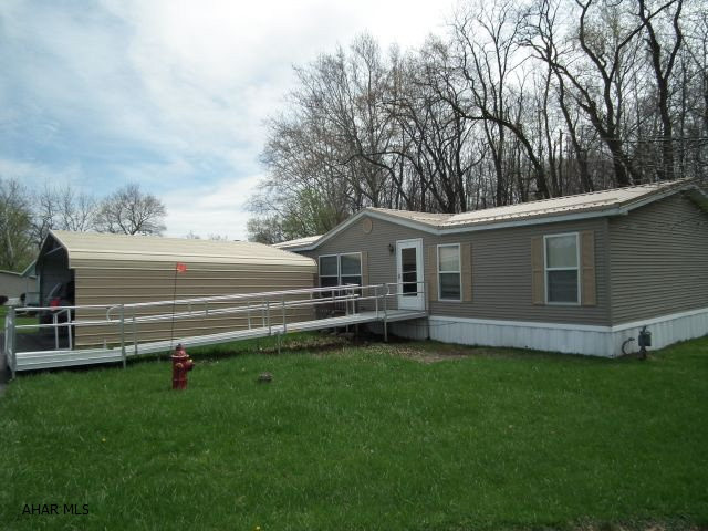 This is priced to sell-New carpeting in living room, master bedroom + master bath-Walk-in closets in all bedrooms. Covered deck in back facing wooded area-Shed included. If buyer would like carpet + handicap ramp removed, seller will remove. Lot rent includes trash, water, sewer, snow removal