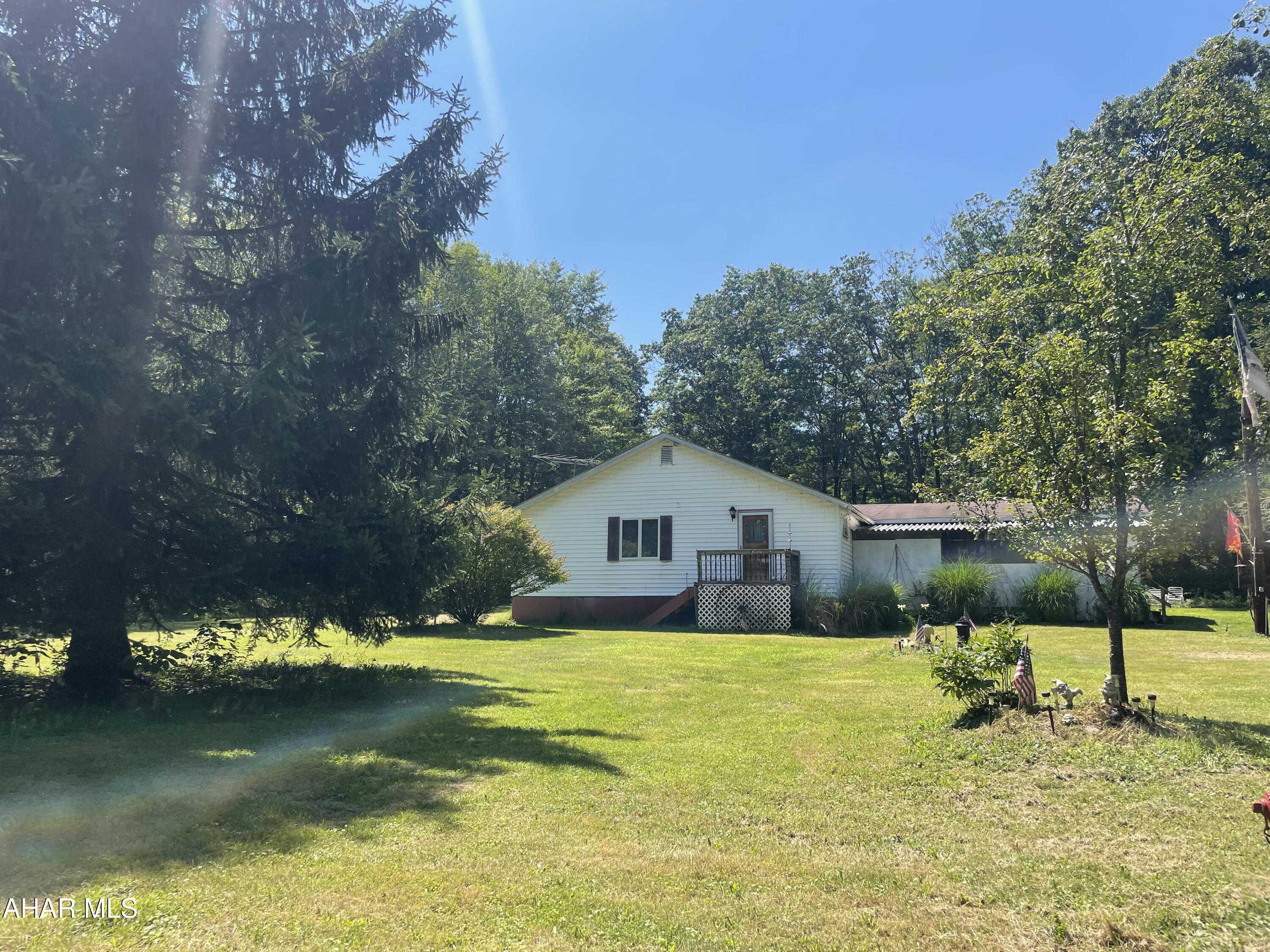 Singlewide mobile home transformed with two additions. 3 bedroom 1 bath. Spacious eat-in kitchen, living room, family room, and laundry room. 2 enclosed porches, great for enjoying the outdoors. Carport. 1.9 acres!!! Extra singlewide on the property, needs torn down.  Being sold AS-IS!!!!!