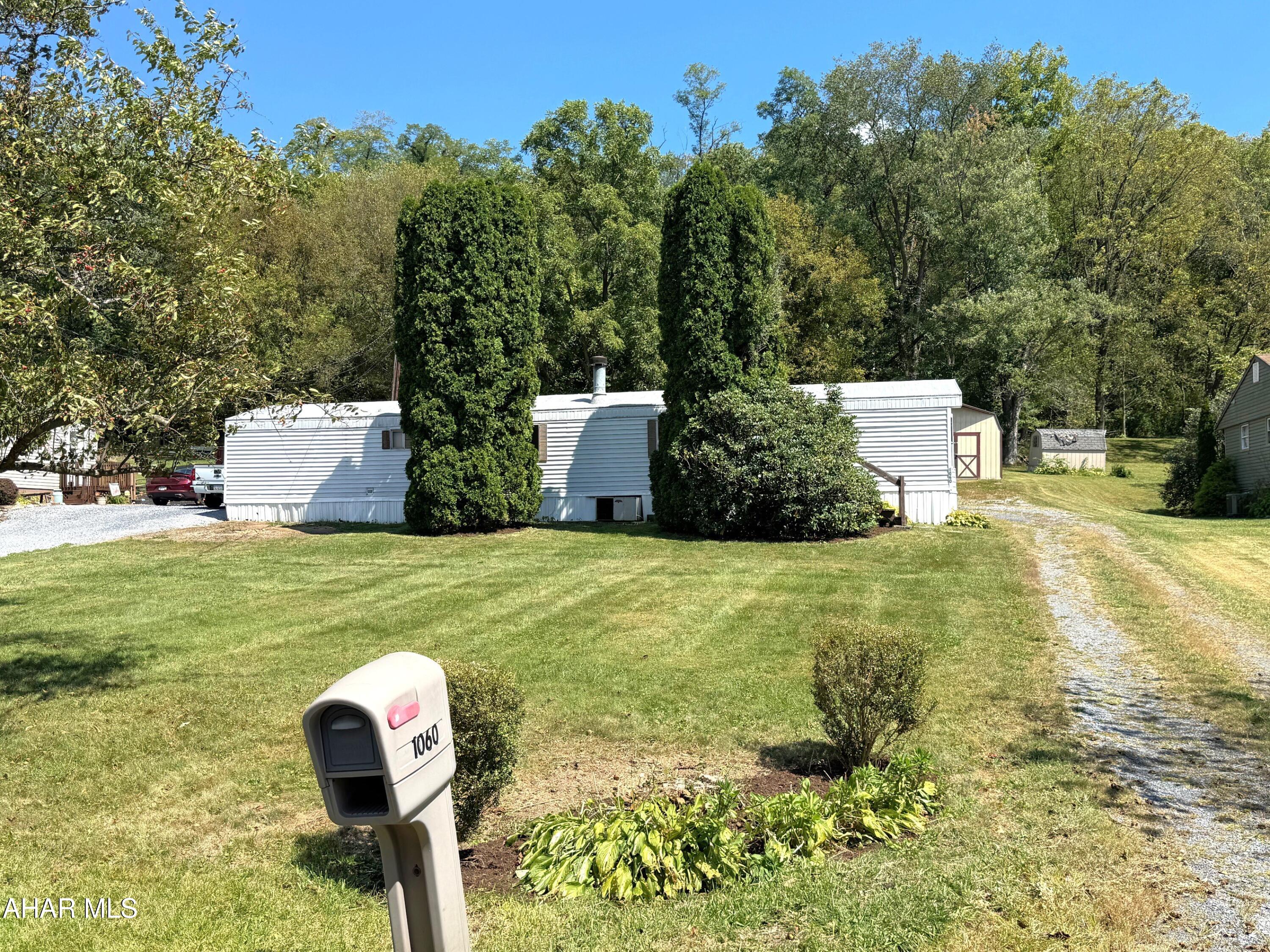 Single-wide mobile home located just outside the Bedford Borough and resting on a spacious .39-acre lot!! This home is a 14' x 66' and contains two-bedrooms, one bath, laundry area, living room with wood burning fireplace, and a kitchen with eat in area. Natural gas forced air heat, central air conditioning, well water and public sewer. Large yard with 12' x 20' storage shed and off-street parking. Convenient location just a short distance from downtown Bedford, schools and supporting amenities. Make this your home, build a home on the spacious lot, or add it to your rental home investment portfolio!