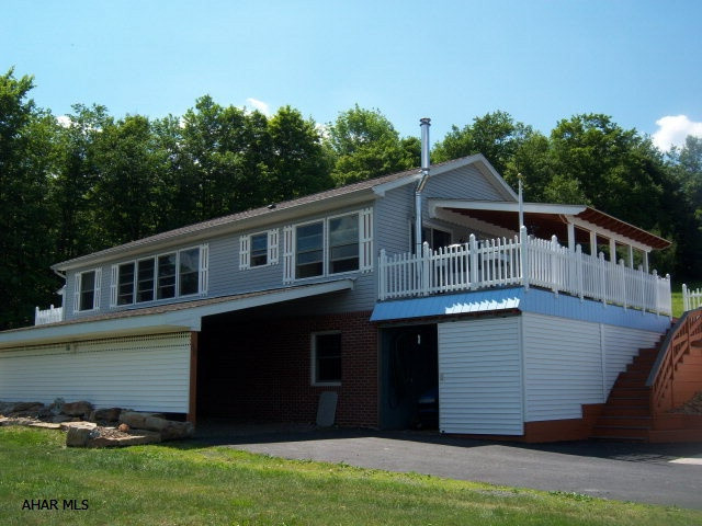 Great natural lighting through out, many amenities. Lots of oak trim adorns the home. Oak kitchen & bath. Spacious living room & master bedroom. Finished basement offers big knotty cedar FR., country kitchen, dining area- great for entertaining. Huge side deck to enjoy the spectacular view in any direction. 2 car garage w/wood working shop plus carport and storage galore & central air. 6.4 acres wood burner supplements heat