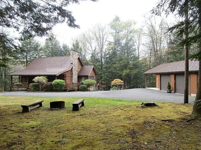 Fabulous wilderness log home on large wooded lot. Living room with fireplace/pellet stove insert. Vaulted beamed ceiling. Second floor loft bedroom with vaulted ceiling. Finished basement with large family room, bedroom and bonus room. Detached two car garage with attached carport. Shed. Rear deck and patio. Quality throughout. Very clean well maintained home. Electric storage heat.
