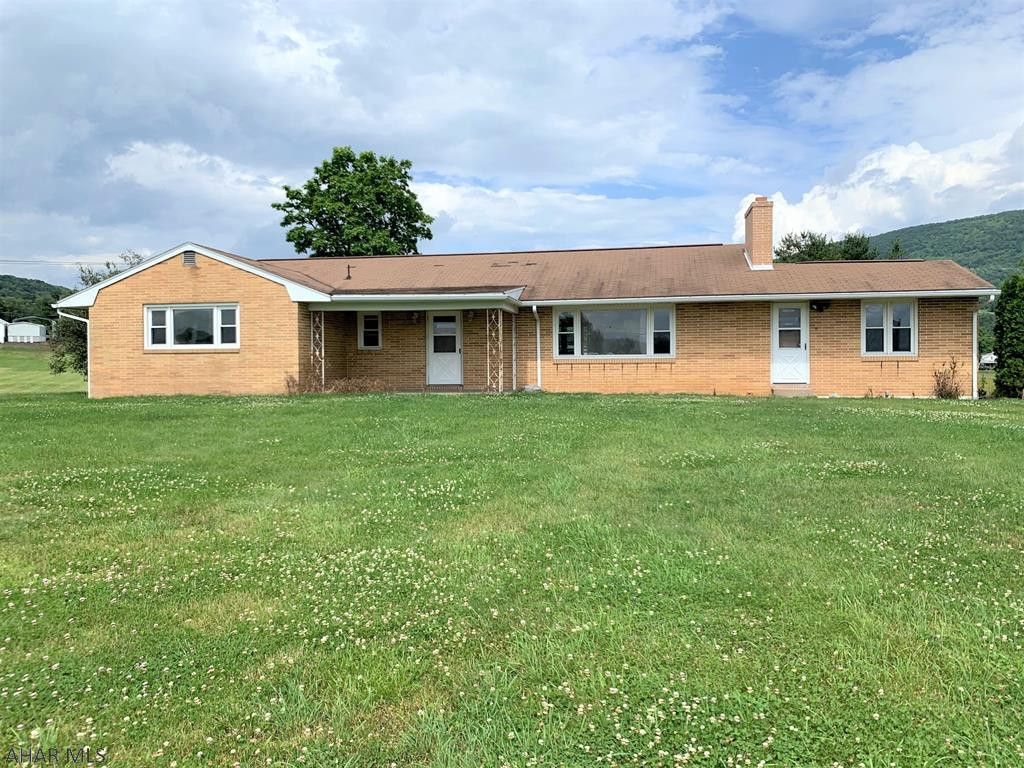 Brick ranch home resting on 3.44 acres with nice views of the surrounding countryside!! It offers a central entry foyer, living room w/ wood fireplace, kitchen, dining room, office/den with built-in shelves, three bedrooms (master suite) and two full baths. Hardwood floors throughout, wood trim-work and lots of closet space. Full basement with an integral garage, oil forced air heat, central air, public water and sewer, and 200-amp electric. Convenient location, easy access to I-99, Blue Knob State Park and Resort, Bedford and Altoona. This could be a very nice home with some updating, bring your own style and make it your home!!  You're getting a lot of home for the money on this one!!