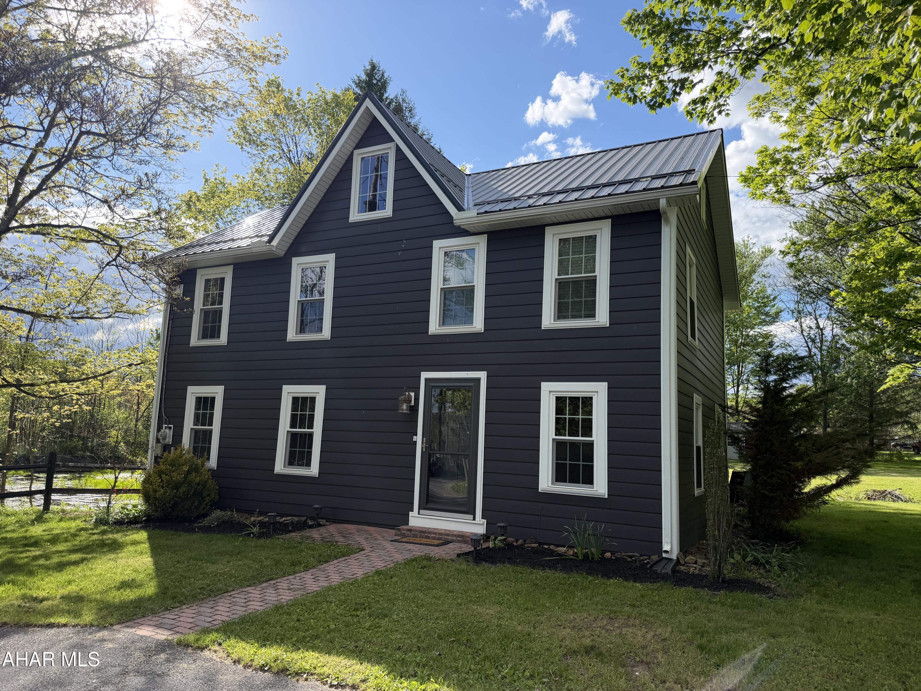 Welcome to this charming, completely remodeled Colonial style home with new windows that come with a life time warranty, doors, appliances and siding completed in 2023. Newer Metal roof. This home was built in 1860 and has tons of original character such as original interior  doors to original exposed beams in the open concept living area. The kitchen is beautiful with  granite countertops, stylish back splash ,additional lighting under the cabinets,  a porcelain farmhouse sink. First floor laundry. Full bath on first floor. Walk up the stairs to a two spacious bedrooms large enough for king size beds and one smaller.  A large full bath on the upper level. Walk up Attic. And then, lets talk about this yard! The landscape is amazing! Beautiful flowers, peach tree & 2 fuji apple trees! Lots of space to entertain family and kids to play. Its very peaceful at night listening to the tree frogs next to the Old Mill Dam. This home is a must see.