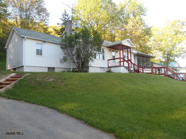 3 BR, 1 bath home in Hollidaysburg School District.  Kitchen was updated in 2008 with new propane stove and refrigerator.  Eat-in kitchen is open to LR with original hardwood floors.  Large screened in porch above the one car garage.  Large 2 car carport on the 2nd driveway.  Master bedroom has sliding glass door to backyard with fire pit.  Situated on large 2 acre lot with grass and wooded area.  Attic is easily accesible with full staircase and great for storage.  Loads of wildlife too.
